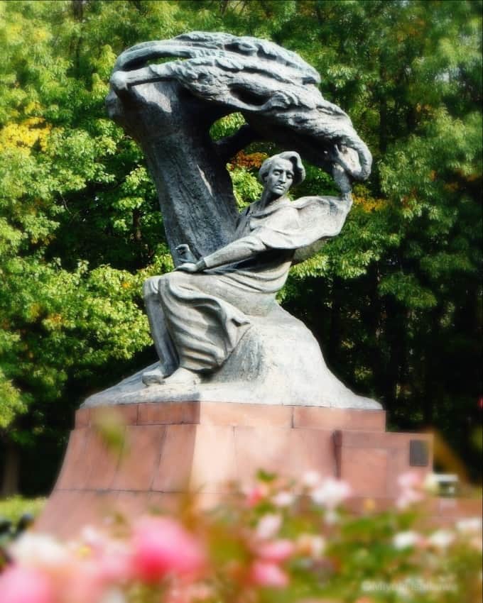 ポーランド政府観光局 ZOPOT w Tokioのインスタグラム：「#chopin　#ポーランド見聞録  #ショパン　#ポーランド音楽　#ポラ旅　#ピアノの詩人　#海外旅行　#ピアノ  #piano #warsaw  #łazienkikrólewskie #lazienkipark #pomnikchopina #ワジェンキ公園  #中欧旅行  #ポーランドの歩き方 🔹現在ワルシャワ・ワジェンキ公園にあるショパン像の製作の話が出てきたのは1889年。ショパン没後40年ということで、それをきっかけにという話でした。🔹しかし当時のポーランドは三国分割の時代で、ワルシャワを統治していた帝政ロシア政府にはポーランド人の愛国心を鼓舞させるショパンの存在は厄介でその像の設置を喜ぶはずはありませんでした。 🔹時が過ぎて1901年。アデライダ・ボルスカというポーランド人女性オペラ歌手がロシア皇帝ニコライ2世よりショパン像設置への同意を口頭で賜りました。これによって、翌年1902年1月1日にロシア総督府からショパン像設置委員会設置の認可が下りたのでした。 🔹1908年にデザインの選定がコンペで行われポーランド人彫刻家ヴァツワフ・シマノフスキの案が選ばれました。当時ショパン像は現在のワルシャワ蜂起広場（Plac Powstańców Warszawy）に設置される予定でした。 🔹彫刻家とデザインの選定はとりあえずやったものの、ロシア政府に案が認められるための条件には帝立ペテルスブルク美術アカデミーの承認が必須になっていました。シマノフスキの案はこの美術アカデミーで没になり、ロシア国務省はアカデミーが不可というならばとショパン像設置を不認可としました。 「芸術性が欠ける、とりわけ柳や水際の蛙について芸術性が欠ける」ということが不許可の理由でした。 🔹このままでは永遠にショパン像の設置は暗礁に乗り上げてしまうという焦りから、建築家で文化遺産修復の専門家でもあったオスカル・ソスノフスキが、シマノフスキの原案の土台部分と池とさらに問題となった不自然なカエルの像を変更した設計を準備し、さらにシマノフスキ自身も柳の木の形に手を加えて改善案としました。なんとか再提出したものの、ショパン像設置委員会がペテルスブルクに送った書類は美術アカデミーと国務省の間を行ったり来たり、相変わらず認可は下りないまま時間ばかりが費やされてゆきました。 🔹それに業を煮やした委員会はペテルスブルクに乗り込んでいき、皇帝の叔母のマリア・パヴロヴナ大公妃に面会して美術アカデミーの承認取り付けを請願し、さらに大公妃の力添えのおかげでニコライ2世はショパン像設置認可を正式に認めたといわれています。 🔹ヴァツワフ・シマノフスキは像の完成を急ぎましたが、第1次世界大戦の勃発と同時期に鋳造を依頼したフランスの鋳物会社が倒産するなどの不運が続き、像の完成は新生ポーランド共和国が誕生してからに持ち越されることになったのでした。 🔹ショパン没後40年の年に設置の話が始まって以来、気の長くなるような過程を経てようやく1926年11月14日に除幕式の日を迎えたのでした。🔹やっと完成したこのショパン像がわずか13年半の後に侵略者の手によって破壊の憂き目を見ることを、幸か不幸か製作者のシマノフスキは知ることなく1930年にこの世を去りました。  第2次世界大戦中ポーランドを占領したナチス・ドイツによって1940年5月31日、爆破され、バーナーで金属屑にされたショパンはドイツに送られました。 🔹さらにドイツ軍は全国の美術館にあったこの像のレプリカもことごとく破壊しました。シマノフスキがポズナンの博物館に寄贈していた1/2サイズの木製像と石膏像も同じ運命をたどり、唯一、頭の部分の模型だけはヴィエルコポルスカ地方博物館の地下倉庫に保管されて終戦を迎えることができたそうです。 🔹ショパン像はワルシャワ市内で破壊された最初の像ともいわれ、それはポーランド人の愛国心を煽るショパンへの憎悪のほか、総督がいたベルヴェデル宮殿からワジェンキ公園のショパン像は目と鼻の先にあったということ、また当時ドイツ第三帝国に向けて金属屑が再利用のために送られるようになったことも理由なのではと言われています。 🔹戦後、ショパン像の再建を目指して完全なレプリカ探しが始まりましたが、戦時中にあらゆる模型が壊されていたことから作業は難航しました。瓦礫となっていたシマノフスキの家から1/10サイズの像が偶然発見され、それと戦前の写真や写真測量法という技術を用いて像の再建が始まりました。こうして今日ワジェンキ公園で出会えるショパンは1958年に完成しました。 🔹この像の下にピアノを設置して日曜日にショパンの音楽を楽しめるワジェンキ公園ショパンコンサートは1959年に始まりました。毎年5月半ばから9月末まで12時と16時に開催されます。 🔸いかがでしょうか？ 観光客でにぎわうワジェンキ公園のコンサート、柳の下で物憂げな表情を見せるショパン像が設置されるまでの歴史を知るとピアノの音色が一段と感慨深く感じられるかもしれませんね。」
