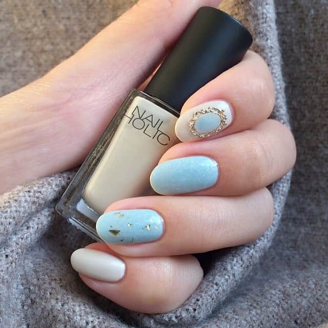 NAIL HOLICさんのインスタグラム写真 - (NAIL HOLICInstagram)「・ ・ 8/21発売、ネイルホリック新色を使った秋ネイルを順次ご紹介中♪ ・ ・ Repost from @m1tab_nail @TopRankRepost #TopRankRepost ⚜️💍⚜️ 控えめブローチネイル。 8/21発売のネイルホリックさん @nailholic_kose の新色です☺️ 新色2色とフレークネイルを使用しました〜💫 【使用色】 ・BL914 ・WT015 ・GD027(発売中) 水色はホワイトとシルバーのチラチラがはいってます。こちらは3度塗り😌ホワイトは塗るときはシマーっぽい感じしたけど仕上がりはあまりわからないかも💭🤔(シマーっぽさでゆうとこないだ塗ったBE312もそーゆう感じでした) 薬指にさらっと乱切りホロ塗って人差し指におしゃれなブローチパーツのせました🙋🏻ブローチの中はBL914をちょんちょんしてます。ブローチパーツはセリアです！もっと爪にあわせて丸みつけないとダメだったな🤢 どちらも上品な仕上がりになるお色です☺️✨ ⚜️💍⚜️ #ネイル #セルフネイル #上品ネイル #オフィスネイル #大人ネイル #ブローチネイル #プチプラネイル #簡単ネイル #ネイルホリック #ネイルホリック新色 #ポリッシュ #マニキュア #お呼ばれネイル #BL914 #WT015 #GD027 #上品 #手元 #おしゃれ #趣味 #女子力 #nail #selfnail #nailholic_kose #polish #simplenail」8月26日 18時31分 - nailholic_kose