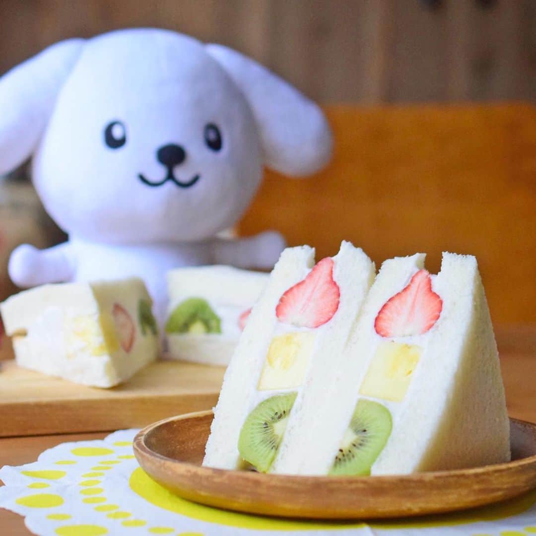 ダスキン ダス犬【公式】のインスタグラム：「【ダス犬とつくろ♪ヘルシー料理】 . おやつや朝ごはんにオススメだよ！ おうちで作ってみてね♪ . . ●ココナッツクリームフルーツサンド ※約3人分 ココナッツミルク缶 400ml お好みの砂糖 大さじ3 コーンスターチ(片栗粉や葛粉でも) 大さじ2 バニラエッセンス 小さじ1/2 お好みの食パン 6枚(今回は6枚切りを使用)  いちご 5〜6粒 キウイ 1個 パイナップル 100g . 1.鍋にココナッツミルク、砂糖、コーンスターチを入れてよく混ぜてから、中火にかける。ゴムベラなどでよく 混ぜながら加熱する。  2.ふつふつとしてきた後に、混ぜ続けてクリームが固まり、重たくなってきたら弱火にして、1分ほどよく混ぜ ながら加熱する。  3.火を止め、鍋を氷水に浸けて、クリームを混ぜながら急冷する。クリームがゴムベラにしっかり乗るくらいま で冷やす。 4.食パンの耳を落とし、フルーツはお好みの大きさにカットする。  5.ラップを広げた上でサンドイッチを作る。1枚の食パンにクリームを厚めに塗り、フルーツを少し埋めるよう に並べる。さらにその上にクリームを塗り、もう1枚のパンを乗せる。軽く押さえながら、ラップで包んだら上 下をひっくり返して冷蔵庫へ。 6.数時間置いてからラップごとカットする。 . ＊MEMO＊ 乳製品アレルギーの子も食べられてヘルシーなココナッツクリーム。 バナナやマンゴー、マスカットなどのお好きなフルーツを使ってサンドしてみて。 . レシピ監修 @iina_veganfoodcreator . #ダス犬とつくろ  #ダス犬と楽しむおうち時間」