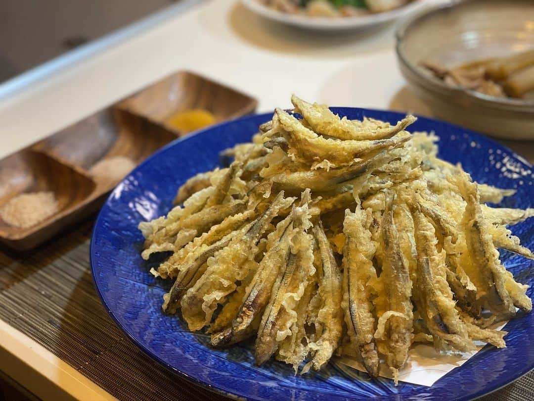 谷崎鷹人のインスタグラム：「春らしい料理2品で家飲みメニュー 菜の花と白身魚の塩昆布和え キビナゴの天ぷら〜3種の塩で〜  我らが料理系YouTuberの殿、 コココロkitchenの大西さん(@cococoro_channel) からの受け取った#料理リレー をバッチリ繋いでいきます！ 未だにインスタが全然使いこなせんけど(　°Д°) 〇材料と作り方 菜の花と白身魚の塩昆布和え ・菜の花 適量 ・お好みの白身魚 適量 (今回のは真鯛とスズキ) ・薄口醤油 適量 ・塩昆布 適量 ・塩 適量 (下茹での時、白身魚の下処理に使う分であって味付けのためのものではありません) 〜作り方〜 バットに薄く満遍なく塩を散らし そこに鯛とスズキの柵を皮目が下に来るように並べ身の方にも薄く塩を打つ (身の薄い箇所には控えめに、身の暑い箇所には少し強めに当てるイメージで)  バットを少し立てた状態に傾け1時間ほどかけて魚の水分を抜く  表面に滲み出た水分はキッチンペーパーでしっかりと拭き刺身としては少し分厚いかな？くらいの厚みに引いたら塩昆布ときざみワサビで和えて冷蔵庫で冷やしておく  その間に大きな鍋にお湯をわかし0.8%〜1%の塩を加えたら菜の花を手に持ちながら茎の部分をお湯につける (この時めちゃんこ手が熱いので御注意)  1分ほどしたら手を離して菜の花全体をお湯にくぐらせる  30秒ほどしたら茎を触ってみて食べれそうな硬さになっていれば間髪入れず氷水に入れてしっかりと冷やす (菜の花の鮮やかな緑色を保つため)  巻き簾に取り潰さないようにしっかりと水分を絞ったら薄口醤油を菜の花にかけて馴染ませもう一度しっかりと水分を絞る (醤油洗いという作業で仕上がりが水っぽくなるのを防ぐとともに醤油の香りがついてめちゃんこ美味しくなります)  食べやすい長さにカットしたら塩昆布を和え冷蔵庫で冷やしておく (和えた直後だとまだ塩昆布がかたいままですがしばらくすると菜の花の余分な水分を吸って全体に馴染んできます)  あとはお皿に盛り付けて上から鰹節を散らせば完成  〇材料と作り方 キビナゴの天ぷら  キビナゴ(食べたい分だけ) コツのいらない天ぷら粉(揚げたい分だけ) 太白ごま油(しっかりキビナゴが泳ぐ程度) 〜作り方〜 キビナゴをボウルに入れ流水で軽く洗い、ぬめりや 汚れを落とす (これをしないと揚げ衣が黒く汚れます)  ペーパーでしっかりと水分を押さえ取ったら 頭も内蔵も全部ついたまんま水で溶いた天ぷら粉にくぐらせて170℃〜180℃の油で揚げる (僕は打ち粉はしない派です) (油に入れるときにシャシャシャっと振ってあげると衣が荒ぶってカリカリな仕上がりになります)  油の中でキビナゴを泳がせながら箸で持った時にシュワシュワとした感覚がしてきたら引き上げる (油から上げる際は一気に取り出して振るのではなく先端を油につけ一呼吸おいてから全体を取り出し最後パッパと油を払うと仕上がりがベチャッとしないのでオススメです♪︎) お皿に盛り付けお好みの塩を添えれば完成 (今回は藻塩、燻製岩塩、カレー塩の3種にしてみました)  どちらのメニューもビール、日本酒、焼酎どれでも相性抜群ですのでちょっと手間はかかりますがご機会がありましたら是非♪︎ 僕からのバトンは マネージャーでもあるオシャレ系YouTuberの ゆーぴー(@yupchannel)に渡します。 ※何気にインスタで登場するのは初めてかも  #おうちで過ごそう #stayhome #料理リレー #cookingrelay  #脇雅也加藤巴里きじまりゅうた杵島直美今泉久美牛尾理恵新谷友里江齋藤菜々子Raluはるあん大西哲也谷やん  #脇雅也 先生 #加藤巴里 先生 #きじまりゅうた 先生 #杵島直美 先生 #今泉久美 先生 #牛尾理恵 先生 #新谷友里江 先生 #齋藤菜々子 先生 #Ralu ちゃん #はるあん ちゃん #大西哲也 先生 #谷やん」