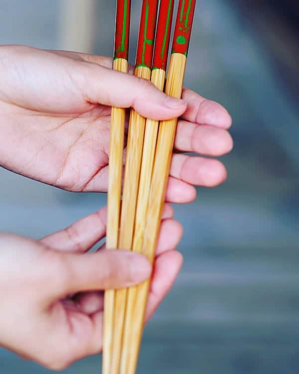 竹虎さんのインスタグラム写真 - (竹虎Instagram)「お箸という漢字は「竹」が冠についているだけあって竹ほどの適材はないと思う。日本全国なら北海道や沖縄を除いて何処に行っても太い孟宗竹や真竹、淡竹が身近にあって材料に困らない。 . 加工にしても、竹を割った性格と昔から言われるように縦に割りやすい、竹林整備を兼ねたキャンプやイベントで竹箸を作られた事のある方がいれば、使い捨てのお箸であれば誰でも簡単に作れてしまう事を実感されてていると思う。自分が山に行ってお箸を忘れた時には黒竹の細い小枝を伐って使った。製作時間は数秒である。 . 軽く、細くてもしなりがあり丈夫、使い心地も最高の竹箸だから古より数えきれない程の量が作られて来たろうし、種類も様々できて来たことだろう。現在でも、竹箸の種類は大きな製造工場で作られるものから、職人手削りのものまで実に多くのものがある。さて、しかし、そんな沢山の竹箸の中で、どれか一膳だけ選ぶとなると一体どうだうろか？ . 自分は、仕事がら沢山の竹箸を持っていて食事の度に色々と変えて使っている。たまに入れ替われもあるけれど、右手でガッと握って一束くらいある中から毎回選んでいるのだ。希少な煤竹を手削りしたお箸がある、極太の孟宗竹を男性用に太く削ったお箸もある、真竹の節が入ったお箸、虎竹の男箸、丸いお箸、角箸、六角箸、漆仕上げ、ウレタン塗装、鮮やかな色に塗ったお箸、その日の気分で並べるお箸の中にプロが選ぶ一膳がある。 . 虎竹のお箸なら嬉しいが、実はそうではない。昭和45年（1970年）から50年近くに渡って竹虎本店で竹箸を販売し続けてきて、自分自身も家族も使い続けて来た母、その母がこれなら間違いないという一膳が研出箸である。値段も800円という普通の竹箸なので肩透かしをくった思いの方もおられるかも知れない。 . ところがある時、竹細工のたしなみがあり竹工芸家から若手職人まで数十年にわたって産地の様々な職人の仕事を見てきた女将と談笑していた時、ふいに竹箸の話しになり奥の台所から長く愛用するというお箸を持って出てきたが、その手にはやはりこの同じ竹箸が握られていた。 . さすがに、この時には鳥肌がたったがプロの目利きが選び続けてきたのは、高級な素材や見てくれの格好良さではない、使いやすさ、耐久性、価格全てにおいてのベストワンの、この竹箸なのである。 . #竹虎 #虎斑竹専門店竹虎 #山岸竹材店 #竹虎四代目 #TAKETORA #竹屋 #竹製品 #竹細工 #竹工芸 #竹 #bamboo #虎竹 #真竹 #青竹 #職人 #国産 #日本製 #竹林 #箸 #最高の竹箸」4月17日 6時05分 - taketora1894