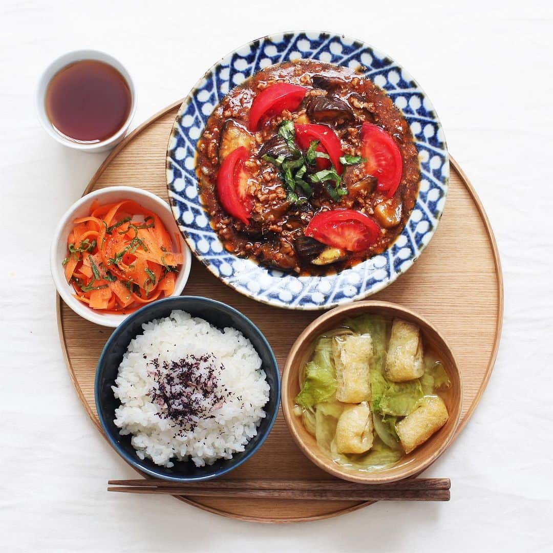 utoshさんのインスタグラム写真 - (utoshInstagram)「【子日記あり】Mabo aubergine with tomato.﻿ 今日はトマト入り麻婆ナスで #毎日の一汁二菜﻿ ﻿ 麻婆ナス、実は麻婆豆腐が食べたいのに豆腐が無い時に作っています。そういう人多いかな〜と思います！﻿ 副菜その他、ささっと作りました。簡単ご飯です。﻿ ﻿ ﻿ 主菜・トマト入り麻婆ナス﻿ 副菜・キャロットラペ﻿ 汁物・レタスの味噌汁﻿ 飯物・ゆかりごはん﻿ ﻿ ﻿ 【子日記】〈親の物をほしがる〉﻿ 子には色々な遊び道具を渡して遊ばせているんだけど、最近特に、親が持っている物をほしがる。という事が増えて、それが手に入らないと泣くって言う。﻿ とくに欲しがるのは妻ががんばって書いている育児記録の日記帳で、「何時に寝た」とか子のことを細かく書いているんだけど、それを欲しがる。﻿ 遊んでるわけじゃないんだよ！って思うけど、とにかく欲しいみたいで、一生懸命ページをめくろうとして、ぐちゃぐちゃにします。﻿ ぐちゃぐちゃにされたくないので本をスッと取り上げると泣く。しょうがないからまた本をあげると一生懸命ページをめくろうとぐちゃぐちゃにする。隣の絵本を開いてあげてもそれじゃだめ。このループを飽きるまでやるんですよね。﻿ でもこれってすごいよねっていつも感心しながら、育児日記をぐちゃぐちゃにされるのは困るな〜と思って見てます。こういうのも赤ちゃんあるあるなのかなぁ？？﻿ ﻿ ﻿ 一汁二菜を食卓に！そして副菜から食べてベジファースト #先ベジ作り置き を取り入れて！﻿ ﻿ ﻿ ぜひ作ってみてくださいね。﻿ No local No food おいしく楽しく！﻿ ﻿ ﻿ #献立 #今日の一汁二菜﻿ #一汁一菜 #とりあえず野菜食 #一汁野菜食 #一汁二菜﻿ ﻿ #ellegourmet#lunch#brunch#breakfast#foodporn#instagramjapan#vsco#IGersJP#onthetable#ランチ#おうちカフェ#うちごはん#暮らし#フーディーテーブル#cooking#おうちごはん#朝ごはん#japanesebreakfast」4月17日 13時45分 - utosh