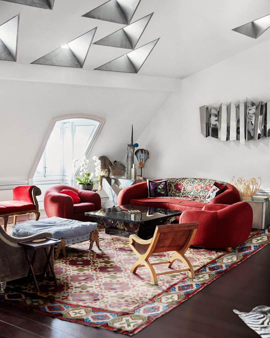 ELLE DECORさんのインスタグラム写真 - (ELLE DECORInstagram)「In our May 2020 issue, we explore the @jacques.grange-designed Paris Penthouse of Christian Louboutin. In addition to the red furnishings—in homage to the designer's highly recognized shoes—throughout, Grange opens up the space for hosting and contrived a side bedroom with no door for privacy when having guests over. In the living room, the vintage red sofa and chairs are by @jeanroyere, the skylights were inspired by the shape of metal cat flaps Louboutin noticed on the roof of a building across the street; he arranged the windows in a peacock pattern. Click the link in bio for the full story. Produced by @whowhatwhit. Photography by @cyrillmatter.」4月18日 7時03分 - elledecor