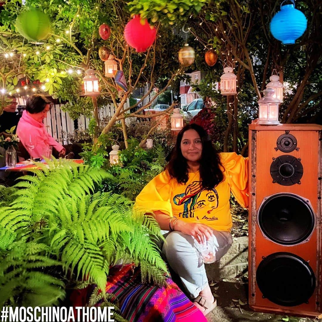 Moschinoさんのインスタグラム写真 - (MoschinoInstagram)「🏠 #moschinoathome goes to visit the Moschino team all around the world. #togetherapart⁣ ⁣ 𝐒𝐮𝐠𝐚𝐫 𝐀𝐧𝐬𝐚𝐫𝐢⁣ 𝐆𝐫𝐨𝐮𝐩 𝐏𝐑 & 𝐂𝐨𝐦𝐦𝐮𝐧𝐢𝐜𝐚𝐭𝐢𝐨𝐧𝐬 𝐃𝐢𝐫𝐞𝐜𝐭𝐨𝐫, 𝐔𝐊⁣ 𝐋𝐨𝐧𝐝𝐨𝐧⁣ ⁣ 𝗪𝐡𝐢𝐜𝐡 𝟑 𝐰𝐨𝐫𝐝𝐬 𝐝𝐞𝐬𝐜𝐫𝐢𝐛𝐞 𝐌𝐨𝐬𝐜𝐡𝐢𝐧𝐨 𝐭𝐨 𝐲𝐨𝐮? ⁣ Normal is boring!⁣ ⁣ 𝐓𝐞𝐥𝐥 𝐮𝐬 𝐚𝐛𝐨𝐮𝐭 𝐲𝐨𝐮𝐫 𝐟𝐚𝐯𝐨𝐫𝐢𝐭𝐞 𝐌𝐨𝐬𝐜𝐡𝐢𝐧𝐨 𝐦𝐨𝐦𝐞𝐧𝐭/𝐦𝐞𝐦𝐨𝐫𝐲. ⁣⁣ I loved the first advertising campaign photographed by Steven Meisel. It was Jeremy’s first season and his collection was stunning in its use of vibrant colour. For the campaign to then be shot in black and white was completely unexpected, but so very beautiful. The casting was incredible, too. I loved every image of that campaign. It was so iconically Moschino!⁣ ⁣ 𝐇𝐨𝐰 𝐰𝐢𝐥𝐥 𝐲𝐨𝐮 𝐜𝐞𝐥𝐞𝐛𝐫𝐚𝐭𝐞 𝐭𝐡𝐞 𝐞𝐧𝐝 𝐨𝐟 𝐬𝐨𝐜𝐢𝐚𝐥 𝐝𝐢𝐬𝐭𝐚𝐧𝐜𝐢𝐧𝐠?⁣⁣ Throw a garden party with loud music, food and lots of drinks for our friends, family and neighbours. ⁣ ⁣ 𝗪𝐡𝐚𝐭 𝐡𝐚𝐯𝐞 𝐲𝐨𝐮 𝐥𝐞𝐚𝐫𝐧𝐞𝐝 𝐚𝐛𝐨𝐮𝐭 𝐲𝐨𝐮𝐫𝐬𝐞𝐥𝐟 𝐫𝐞𝐜𝐞𝐧𝐭𝐥𝐲?⁣⁣ Love thy neighbour!!! ⁣ Something lovely occurred once we were in isolation. We check on one another and help some of our older, more vulnerable neighbours. We have all started to use our front gardens a lot more. We carved a large hole in the hedge dividing our gardens so we could see each other (still observing the 2 meter social distancing rule). We decorated the area with fairy lights and lanterns. We call it Cafe Rona. We have tea out there most evenings. On the weekend the Cafe becomes Bar Rona and we have music and G&Ts. It’s been amazing connecting with our neighbours. Previously we all sat in privacy in our back gardens keeping ourselves to ourselves. ⁣ ⁣ 𝗪𝐡𝐚𝐭 𝐢𝐬 𝐲𝐨𝐮𝐫 𝐛𝐨𝐨𝐤/𝐟𝐢𝐥𝐦/𝐫𝐞𝐜𝐨𝐫𝐝/𝐚𝐥𝐛𝐮𝐦 𝐨𝐟 𝐜𝐡𝐨𝐢𝐜𝐞 𝐫𝐢𝐠𝐡𝐭 𝐧𝐨𝐰?⁣⁣ I’m reading "The New Girl" by Harriet Walker @_harrywalker1⁣ Ironically I’m watching THE END OF THE F***ING WORLD on Netflix. ⁣ I’ve been listening to Lana Del Rey‘s cover of Sublime’s "Doin time". I love this song so much, I often have it on repeat, It’s driving my husband mad 😂⁣ ⁣」4月18日 22時51分 - moschino