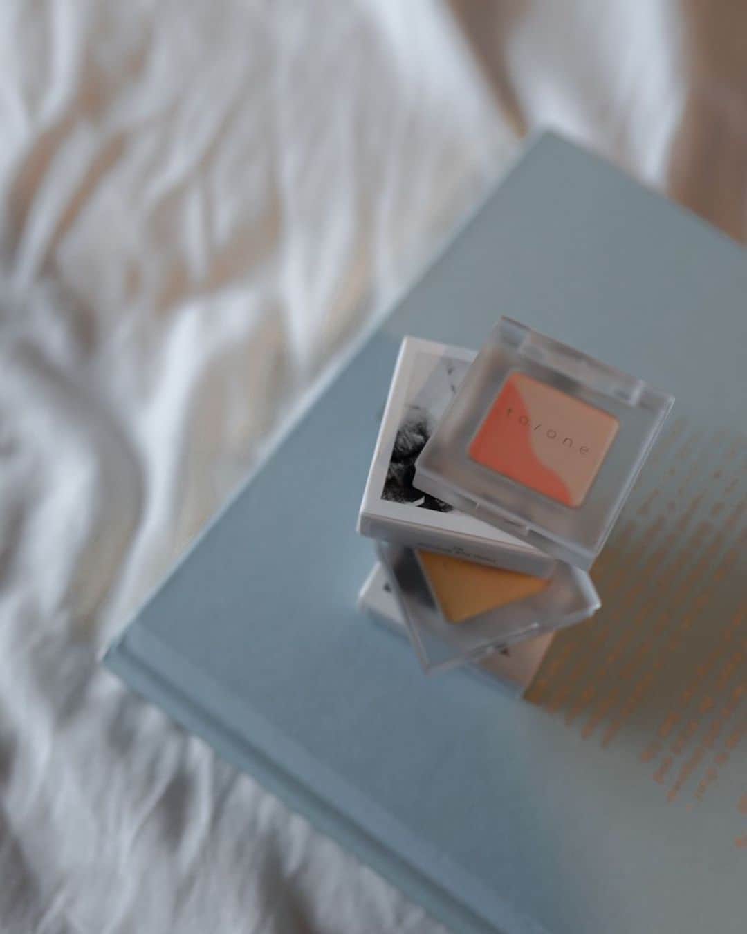 紺谷みえこのインスタグラム：「新色が出ると完売らしい。アイシャドウは @toonecosmetics (トーンと言う名前もかわいい)  ナチュラル& オーガニックメイクアップブランドで ウチワサボテンオイル🌵とフラワーエキス🌼配合  出勤時は顔半分がマスクで隠れているので、 目元に色味を足してひそかに楽しんでいます。  オレンジ02  ゴールドイエロー03  #トーン　#アイシャドウ　#お気に入り　#ツヤ感　#春カラー　#コスメキッチン　#オーガニック　#ナチュラル　#美容　#toone #cosmetics #beauty #skincare  #eyeshadow」