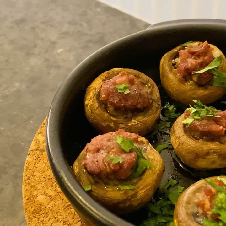 馬場裕之のインスタグラム：「juicy mushroom🍄 材料 マッシュルーム 生ハム（ベーコン、ソーセージ、サラミなど加熱しないでも食べれるものでなんでも） 玉ねぎみじん切り パクチー（パセリ、イタリアンパセリでも） オリーブオイル 塩胡椒 マッシュルームの軸をひねってとる、軸はみじん切りにしておく（あとで使えます） 玉ねぎをみじん切り、生ハムを細切りにする 軸をとったマッシュルームに軽く塩をふり、玉ねぎみじん切りを少し入れ生ハムをのせる。 玉ねぎをもう少し加熱したい場合は生ハムを入れてから玉ねぎを上に重ねる。 耐熱容器に並べて上からオリーブオイルを回しかける。 オーブントースターで10分加熱（僕のトースターの場合なので、マッシュルームから水分が出て上の具材が少し焦げるまで加熱する） 焼けたら黒胡椒、刻んだパクチーをのせて完成。 余った軸のみじん切り、玉ねぎみじん切り、生ハムをオリーブオイルで加熱してパクチーを混ぜてパンにのせて食べても美味しいですよ。 #おうち時間  #おうちごはん #吉本自宅劇場  #馬場ごはん」