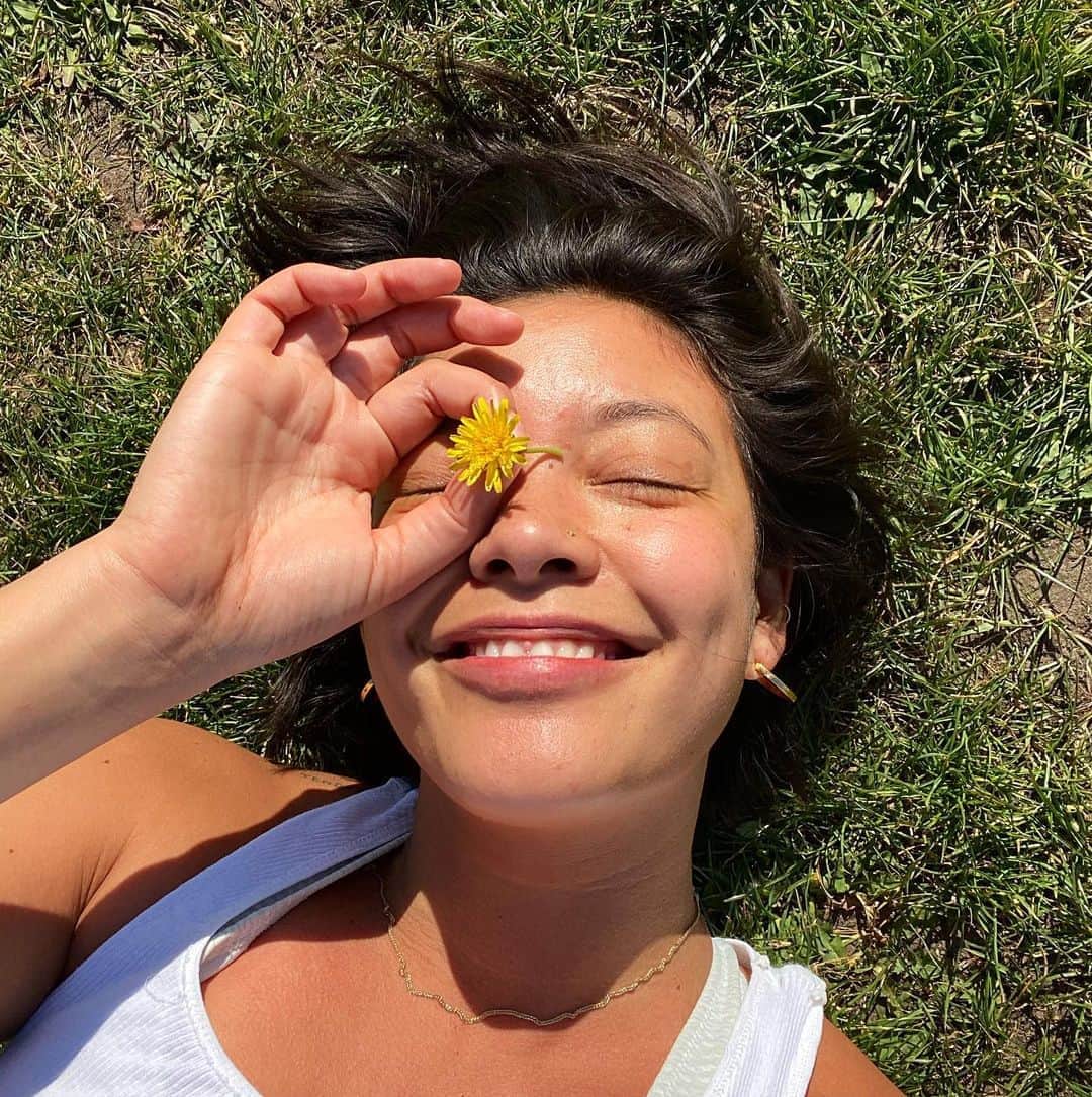 ナオミ・シマダのインスタグラム：「over the last few weeks I’ve been noticing more dandelion growth than I feel like I’ve ever seen in my life!!! these little sunny dandy’s get forsaken for weeds but are so rich in medicine and symbolism and their ability to thrive under the harshest of conditions can teach us so much about persistence and survival. dandelions can burst through the cracks of walls and sidewalks, a triumphantly defiant bit of green standing so strong. the deep taproots remind us to ground ourselves deep into the earth, so we can stand strong no matter how life’s winds blow. we can take so much from the opening and closing of the flower, and its transformation into an adorable lil puff of seed, it teaches us about ourselves as we first show ourselves off, then  quietly retreat, then return in a different form. the seeds journey helps us understand there are times we have to blow away and become something new. I once went to see an indigenous plant healer from the Amazon speak and he shared with us that the plants that grow around us, grow there because they’re the plants we need the most. feeling grateful to the dandelions for reminding me of our ability to not only survive and rise above what life throws at us but how we can adapt and play a part in shaping what that future looks like. thank you lil sun beam dandelions for brightening up my day and for reminding me that we are actually so very resilient and strong 🌼 XXX love」