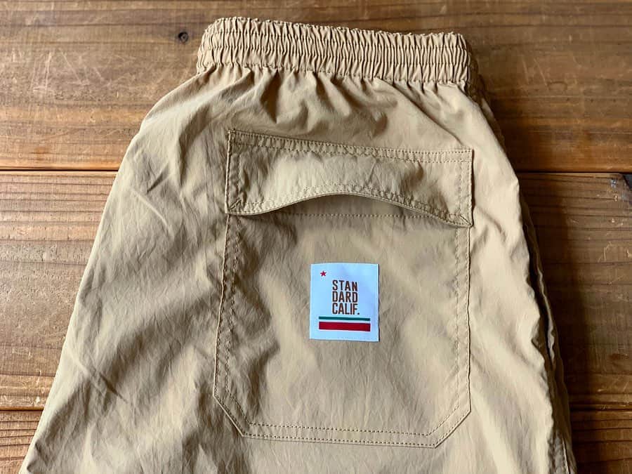 のインスタグラム：「今回のComfortable Easy Pantsは、ポケットから物が落ちにくいように、サイドポケットにはボタン付きのメッシュポケット、バックポケットにはフラップをプラスしました。 裾のドローコードで気温や目的に合わせてレングスを調節できるように。  #standardcalifornia #スタンダードカリフォルニア  #easypants #イージーパンツ #ナイロンパンツ #pants #fashion #ファッション」