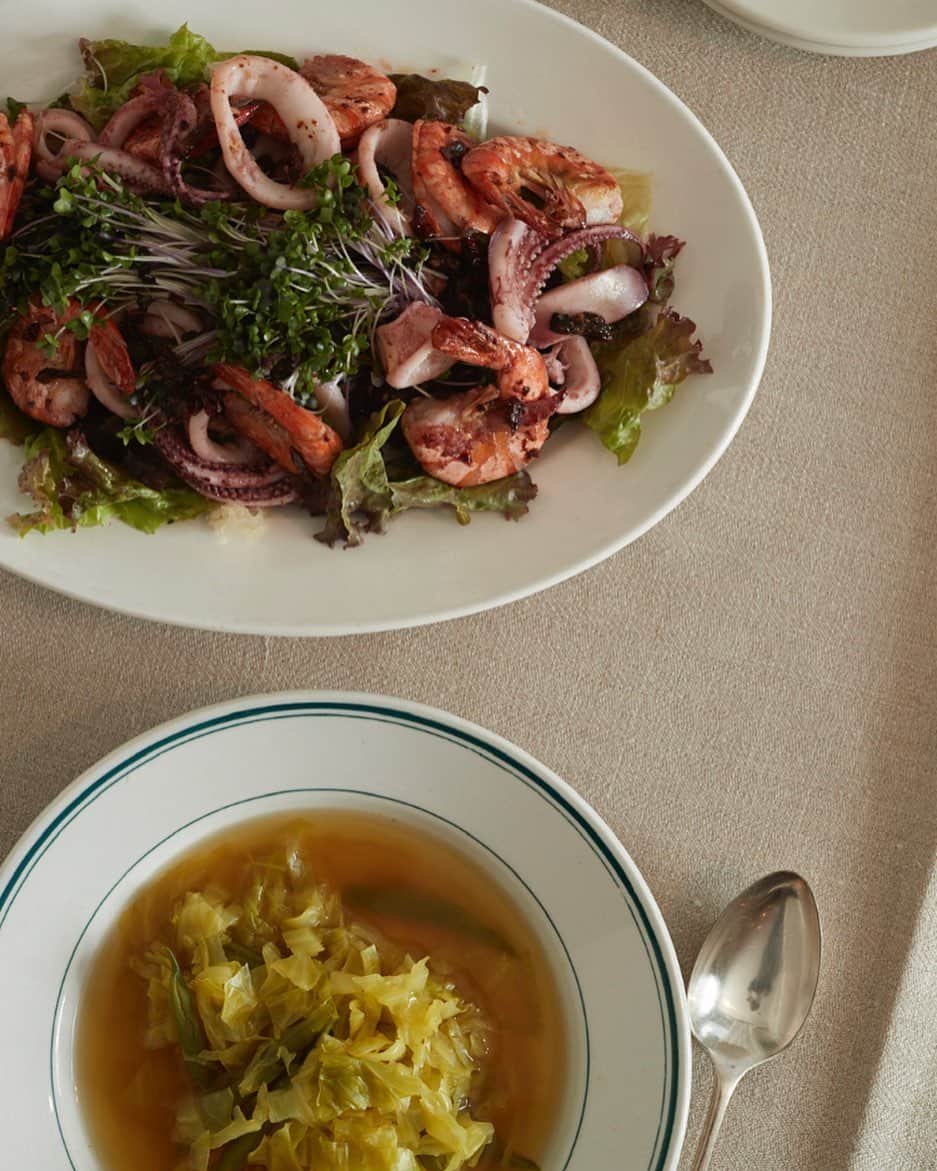 サルボ恭子さんのインスタグラム写真 - (サルボ恭子Instagram)「ちょっと、いやかなり﻿ 食べすぎの今日この頃。﻿ ﻿ スーパーで﻿ 海老とイカをもとめ﻿ ニンニクとハーブ﻿ 塩こしょうで味付けソテー、﻿ サラダの上へ。﻿ きのこもいれるとボリュームアップ。﻿ ﻿ 刻んだ春キャベツを　﻿ 塩と水で煮込んだスープ。﻿ ほんのりカレーをきかせて﻿ 仕上げにバター。﻿ ベーコンやソーセージ、﻿ ひき肉を少しいれても。﻿ ﻿ 今夜の2品献立はこれで、﻿ ご飯やパンはなし﻿ ﻿ ワインを開けて、﻿ また今週も無事に﻿ 過ごせたことに感謝しつつ、﻿ ゆっくりいただきます。﻿ ﻿ stay home et﻿ restez chez vous.﻿ ﻿ ﻿ #フランス共働き家庭の2品献立#立東舎#cookpadnews#stayhome#restezchezvous#サルボ恭子 #kyokosalbot#mybook#meslivres」4月26日 16時41分 - kyokosalbot