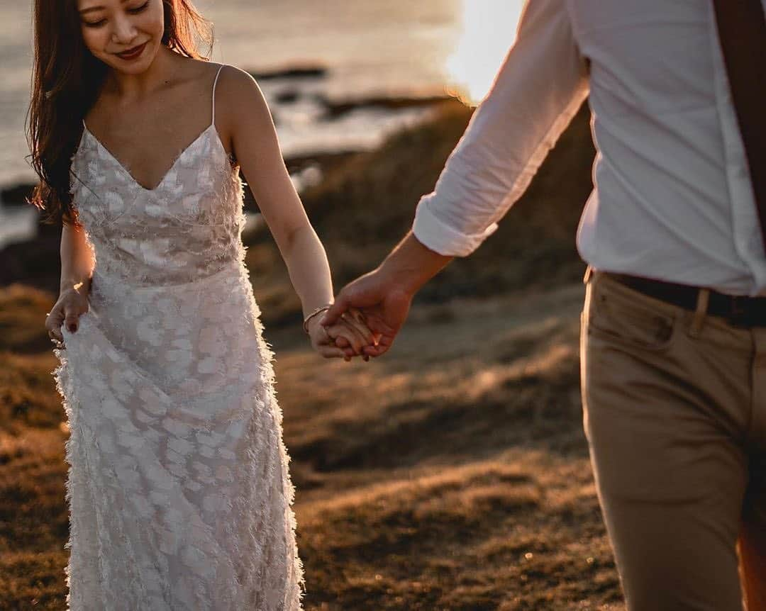 25ans Wedding 公式 Bridesのインスタグラム：「今日は萌映子さんのフォトをリポスト。夕日に照らされたふたりがとってもロマンチック💓 エフォートレスなキャミソールドレスがリラックスした魅力を引き立てます。シンプルなデザインだからこそ、素材感で差をつけて😌」