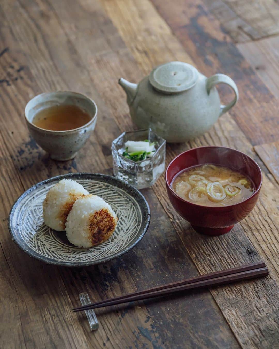 Nanaのインスタグラム：「撮るまでもない滋味ご飯。 本醸造のお味噌にはネギとお豆腐を入れているのだけど、ネギだけの方が互いを引き立てあって美味しさが際立つなと思った、昨日の朝食。 焼きおにぎりは、米麹の醤油漬けで。定番メニュー。醤油麹は麦麹が好きなのだけど、手に入らないので米麹で。自分で作れば良いのかな。。 . おにぎりは八田さんの黒三島五寸皿に、香の物は西山さんの角ぐい呑みに盛り付けて。」