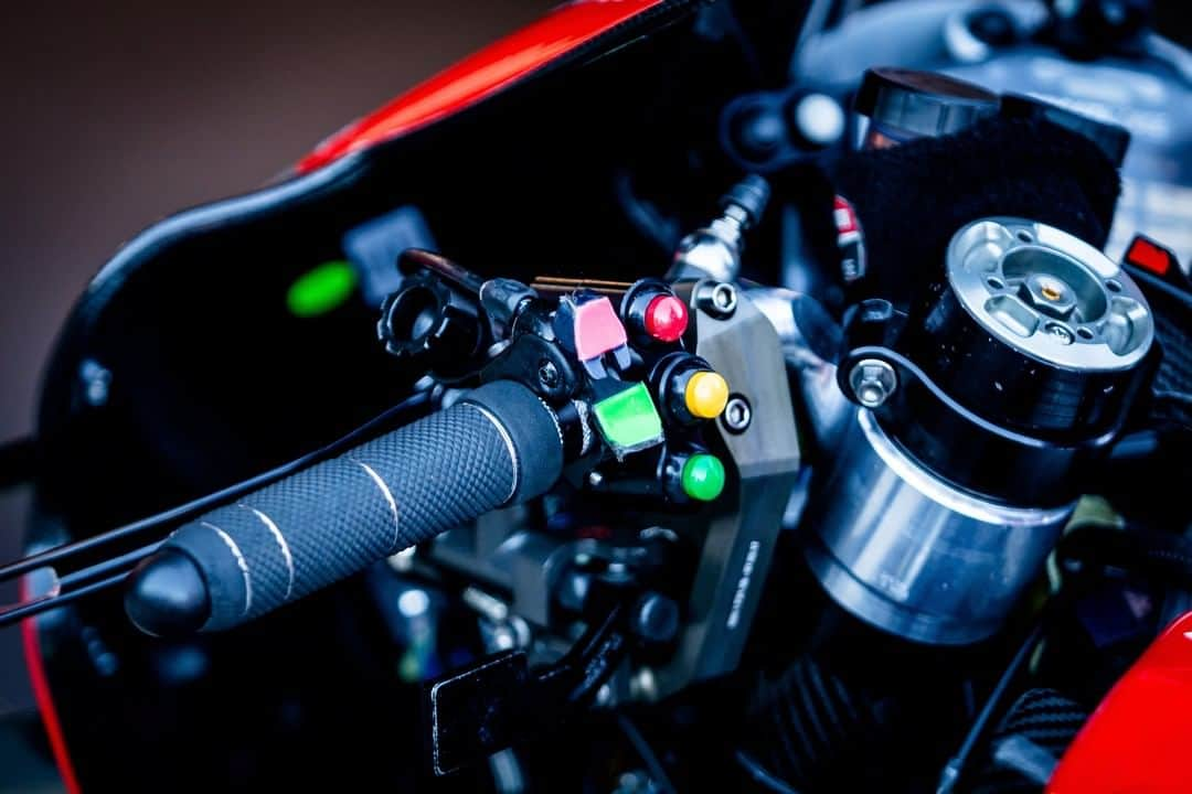 MotoGPさんのインスタグラム写真 - (MotoGPInstagram)「#MotoGPInParts - Handlebar Controls. In #MotoGP, the number of buttons around the handlbar is limited to as few as possible for simplicity to rule out any confusion for the rider 🔢  Firstly, the square red and green levers. This is the lever to activate Ducati's ride height device. Pushing one of the square levers activates the system, allowing the rear end of the bike to be lowered and then pushing the other square lever releases the system, allowing the bike to spring back to its normal ride height! ⬆️ The three buttons to the left are all to do with the bikes electronics. Ducati used to have a 5 button system, but this was recently changed when the rider height adjuster was introduced. The 5 buttons back then were for engine mapping, launch control, fuel mapping, pit lane limiter engine brake settings. We suspect that now, the three buttons are for power mapping, fuel mapping and engine brake settings with the buttons for launch control and pit lane limiter being moved to another location 🔄  Something else here is obviously we have the clutch lever infront of the handlbar, below we also have the lever for the thumb-operated rear brake and all the way in the top right, with the red square sticker on it, we can just see the wingnut to operate the holeshot device! 🎮  If you like this style of post, make sure you check out our 'MotoGP Tech' Facebook group! 🙌」4月28日 16時00分 - motogp