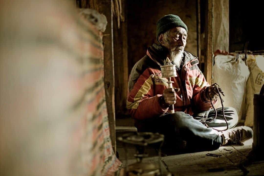 Cory Richardsさんのインスタグラム写真 - (Cory RichardsInstagram)「Karma Tsering Sherpa sits in meditation in his home in the village of Phortse, Khumbu Valley, Nepal. ⁠ ⁠ I made this portrait 11 years ago while on a climbing trip with one of my best friends and creative-collaborator, @renan_ozturk. Karma himself is nearly Sherpa 'royalty' and has appeared in feature films as well as in the pages of #natgeo. His life story has been told piecemeal via vignettes (like this one) for years. If you ask him how old he is, the answer takes form via an animated rummaging-through of Tibetan calendars, fragile yellowed pages turned under a shaking magnifying glass. No clarity is offered. Suffice to say he's seen a lot, from the first expeditions wandering up the valley to the airplanes and helicopters buzzing overhead. ⁠ ⁠ Last time I saw him, he was perched on his rooftop hang, staring up at the mountains. ⁠ ⁠ #BespokeCoryRichards⁠ @bespokereps」4月29日 1時01分 - coryrichards