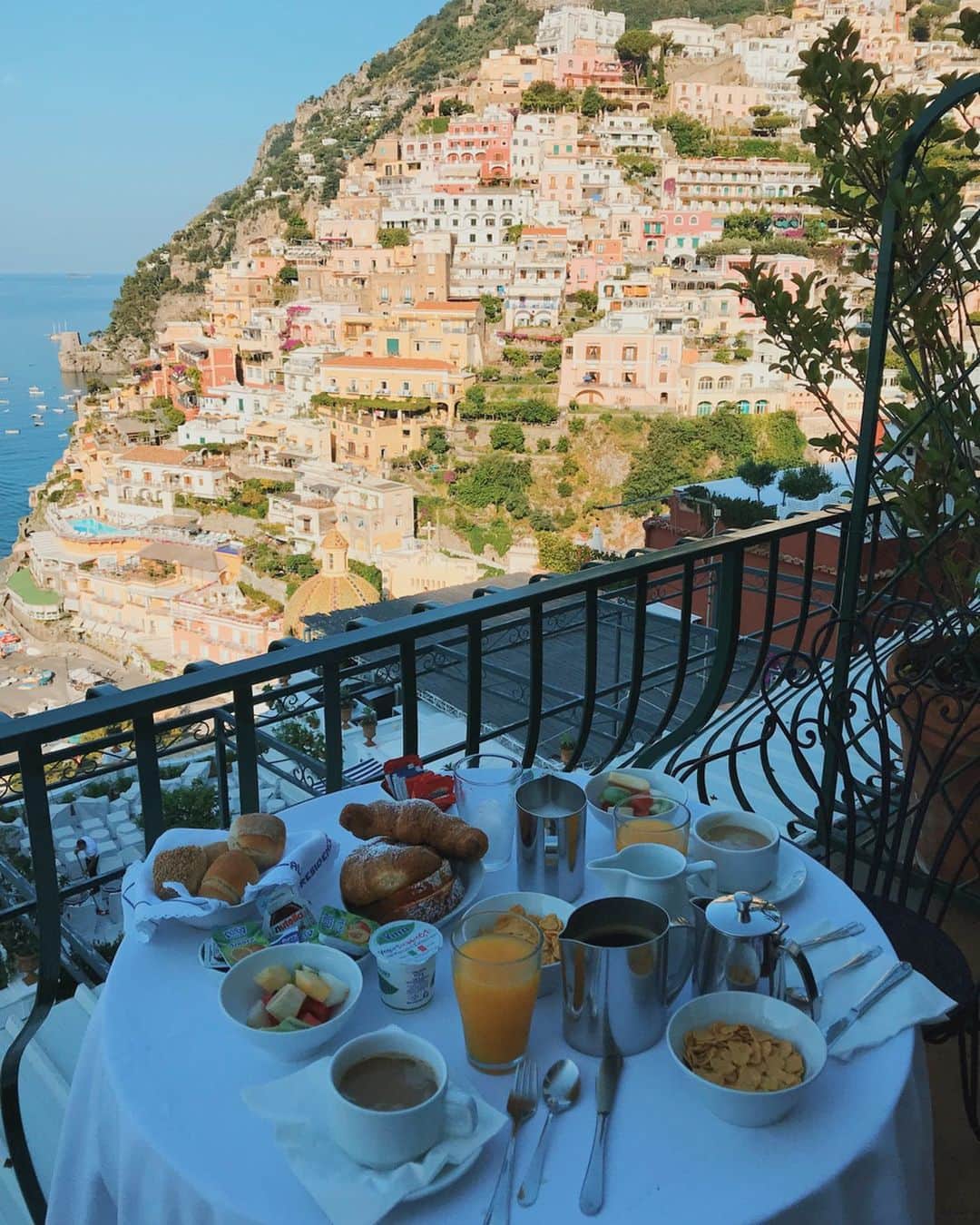 小竹麻美のインスタグラム：「2018 June｜ Positano ITALY 南イタリアのカラフルな美しすぎる街ポジターノへ。 フェレンツェ滞在後、TRENITALIAとフェリーを乗り継いで到着。（この日は嵐のような豪雨でフェリーでの船酔いは人生イチ😱）けどそんなことも忘れてしまうくらいの美しい街並み。初の南イタリアの大興奮🇮🇹 カラフルな建物で街全体が崖に面しているためアマルフィ海岸がどこからでも見えるの🥺❤️ 朝ごはんだって毎朝この光景に感激。その分、どこに行くにも急坂か階段で毎日筋肉痛だった〜。 そして、どこのお店に入っても、とにかくパスタが絶品！あとトマト！🍅色の鮮やかさから違うしフルーツみたい！カプリ島へも日帰りで遊びに行けて幻のような旅行でした🥺また行こうね〜〜❤️ #positano#amalficoast#italy#italia#trip#ポジターノ#イタリア#南イタリア#アマルフィ」