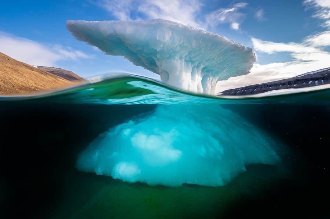 ナショナルジオグラフィックさんのインスタグラム写真 - (ナショナルジオグラフィックInstagram)「Photo by @daviddoubilet | Wind and waves sculpt a grounded iceberg in Blanley Bay, in the Canadian Arctic. We discovered a shallow bay filled with several grounded icebergs that reminded me of living Arctic art. It was both magical and sad swimming through this cold and gleaming gallery of once great icebergs that were slowly disappearing and becoming one with the sea. I like to photograph half-and-half images because they make a connection between the surface and the secret world below. #Iceberg #Arctic #AboveAndBelow」4月29日 4時34分 - natgeo