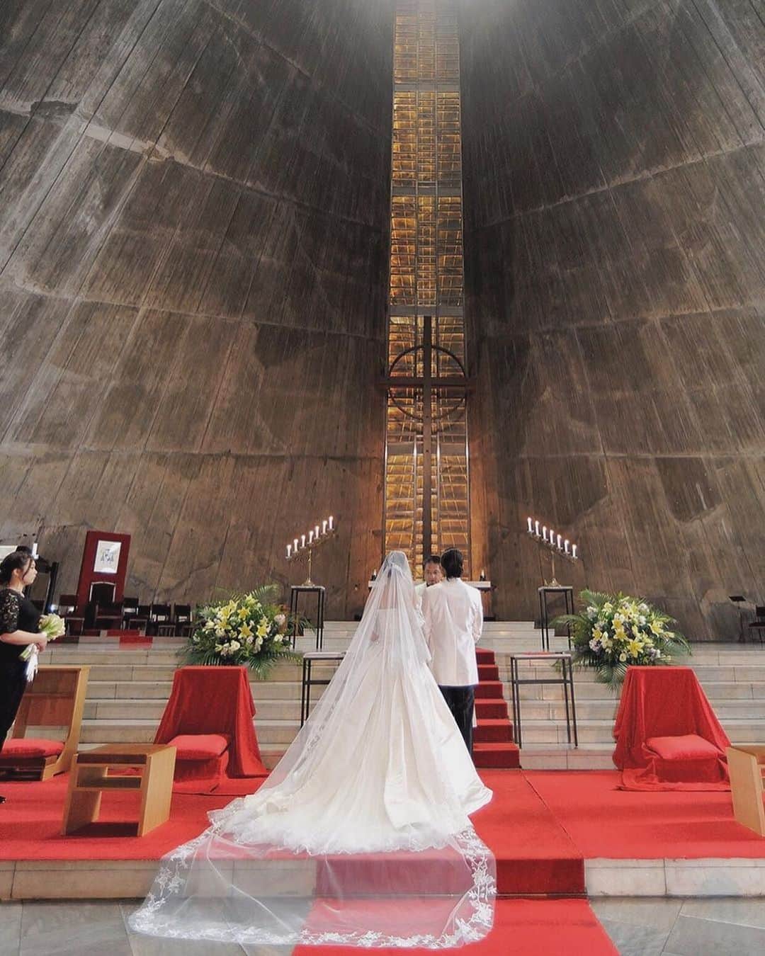 25ans Wedding 公式 Bridesのインスタグラム：「今日は、「東京カテドラル聖マリア大聖堂」で挙式したちのさんのポストから📸 日本を代表する建築家・丹下健三が設計したチャペルは、洗練され厳粛なムード🕊「アールユキコ」のクラシカルなドレスで、花嫁らしい上品な魅力を引き立てて💫」