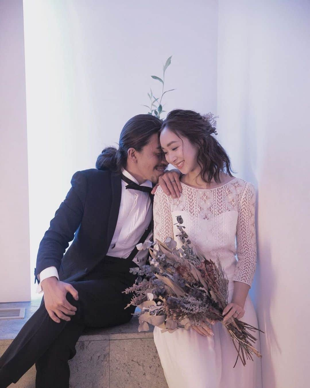 25ans Wedding 公式 Bridesのインスタグラム：「今日も、ちのさんのフォトをリポスト。モードな抜け感が漂うエフォートレスドレスには、シックなドライブーケが好相性🥀  ヘアにもドライフラワーをさりげなくあしらって、シンプルにまとめるのが大人な雰囲気🌝」