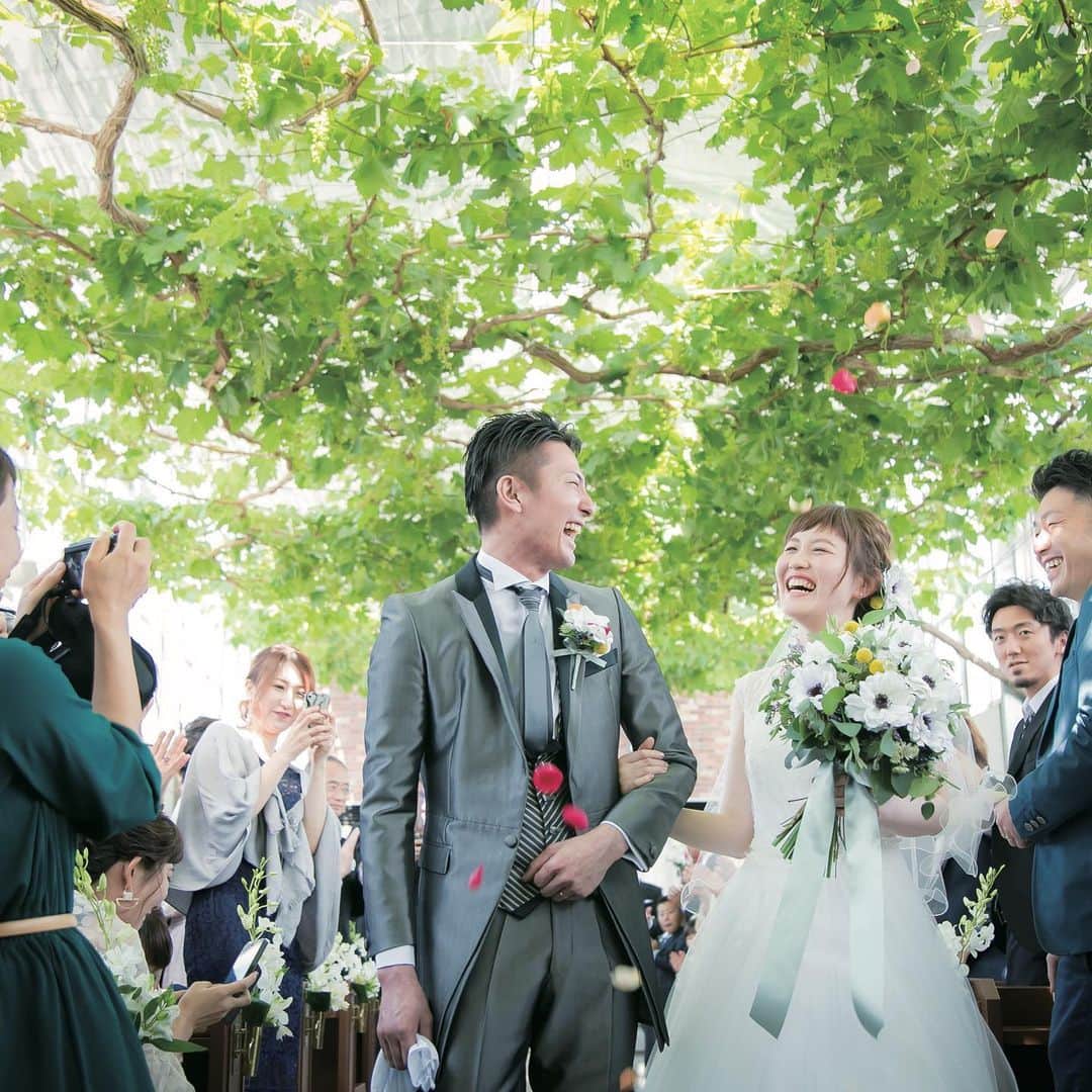 ゼクシィさんのインスタグラム写真 - (ゼクシィInstagram)「【ゲストの印象に残る 季節感のあるウエディング5月編🌿】 . 日本の四季は装飾やお花、料理、演出、 あらゆるものに取り入れることができるため、 テーマやアイテムに反映させる方も多いのでは😌？ . 今回は結婚式に“季節感”を上手に取り入れた 5月婚の卒花実例をご紹介。 . ナチュラル感があり、みんなと距離感の近い ウエディングが理想だったので、 5月らしい爽やかな緑に包まれた ぶどう園を舞台に選んだふたり🍇 . このロケーションにピッタリの草木を モチーフにしたアイテムを取り入れ、 心地よい屋外の雰囲気を満喫するプログラムも満載☺️✨ . 他にも季節感を取り入れたポイントなど ご紹介しているので、#ゼクシィアプリ をチェックしてくださいね。 「【卒花実例】ゲストの印象に残る 季節感のあるウエディング［春夏編］」 . 西田さま . +♥+:;;;:+♥+:;;;:+♥+:;;;:+♥+:;;;:+♥+:;;;:+♥ . プロポーズから結婚式まで素敵なお写真募集中！ . ゼクシィ公式アカウントでお写真を紹介してみませんか？ 【#ゼクシィ2020】 を付けて投稿してください📷💚 . +♥+:;;;:+♥+:;;;:+♥+:;;;:+♥+:;;;:+♥+:;;;:+♥ . ▼花嫁さんダウンロード数No.1 ゼクシィアプリはURLから🌼 @zexyrecruit . . #テーブル装飾#テーブル装花#ゲストテーブル#メインテーブル#ゲストテーブル装飾 _ #ゲストテーブル装花#テーブルコーディネート#リースブーケ#ブルードレス#春婚#ナチュラルウェディング#デザートビュッフェ#ガーデンウェディング#卒花嫁 _ #2020冬婚#2020秋婚#2020夏婚#2020春婚#結婚準備#結婚式準備#全国のプレ花嫁さんと繋がりたい#日本中のプレ花嫁さんと繋がりたい#5月婚#ブライダルネイル _ #プレ花嫁#ゼクシィ#ちーむゼクシィ#プロポーズされたらゼクシィ」5月1日 12時12分 - zexyrecruit