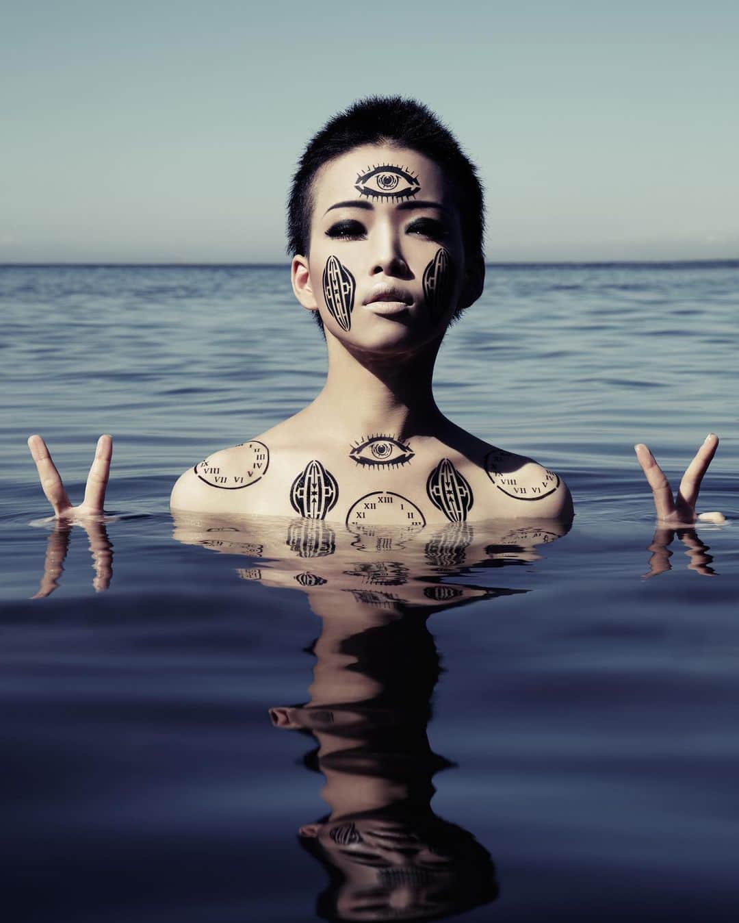 のインスタグラム：「たまにはアーカイブも載せていこう。2012かな。﻿ VAGINA時代にBeautiKっていうビューティーブティック(ラフォーレ原宿にあったKaori.Kさんのお店)とコラボしたときの作品。﻿ お店に行けば、エアブラシでこの図を吹き付けてペイントしてもらえるイベントを開催した。﻿同柄のタトゥーシールも販売したな。﻿ ﻿ 池田ひらりを海に沈めた回。海坊主を撮りたかったの。﻿ 水面ギリで撮ってて、突然の高波にカメラマン上村さんの大事なカメラが水没しかけたw﻿ ﻿ ﻿ ﻿ —﻿ VIVE VAGINA x BeautiK USLUAIRLINES AIRBRUSH ART﻿ (2012)﻿ ﻿ – 第○の眼 – 世の中は、素晴らしい物で溢れています。 たった二つの目だけでは とてもじゃないけど見きれないよというあなたに、もうひとつ目玉をプレゼント。﻿ ﻿ – 13時間時計 – 一日がもう少しだけ長ければ、、そんな忙しい方にぴったり。 13時間時計を身につければ、世界の秩序から解き放たれて自由という名の地獄を生きる事ができるでしょう。﻿ ﻿ – VIVE VAGINA のヴァギナマーク – けしからんマークに街行く人の視線を独り占めできること間違い無し。でも始まりの場所ってこと、忘れないで。﻿ ﻿ ﻿ Photo – Tadayuki Uemura﻿ Model – Hirari Ikeda﻿ Dir – Si oux」