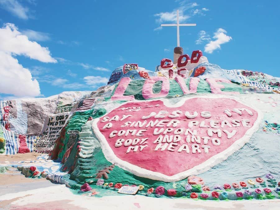 小竹麻美のインスタグラム：「2016 May |  Salvation Mountain パームスプリングスから1時間半くらいドライブ。長ーいTHEアメリカ的な、道をまーっすぐ進むと🚘なにもない場所に、突如現れるサルベーションマウンテン💛💚🧡 （LAから行くなら、パームスプリングスに泊まってからいくのがおすすめ♡） わたしが想像していたよりも、この空間は広くて、中もびっしりとアートされていて感激した！なによりやっぱりこの広い青空にこの巨大カラフルな山はテンションあがる🥺✨ 4年前の写真なんだけど、人の手によって作られたものだからどんどんこの鮮やかな色たちも褪せていってしまうんだろうなぁ。。今はどうなっているんだろう！また行ってみたいよ〜🌈 . #godisLOVE#salvationmountain#california#losangeles#palmsprings#サルベーションマウンテン」