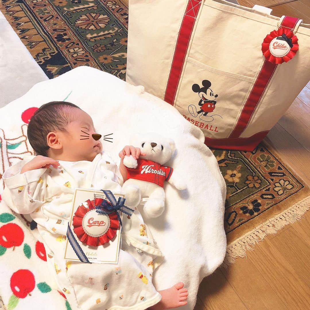 うえむらちかのインスタグラム：「#カープ女子化計画 ❣️﻿ ﻿ うちのべびちゃん（姪っ子ちゃん）﻿ を #カープ女子 に育てるべく﻿ 早くもカープの英才教育が始まりました🕶✨﻿ ﻿ 名前入りの﻿ #カープロゼット﻿ をプレゼント🎁﻿ （表に名前、裏にcarpって書いてあるの）﻿ ﻿ 私も一緒に作って﻿ お揃いにしちゃいました😍﻿ （叔母バカの自覚はあります笑）﻿ ﻿ ﻿ 🏵ロゼットはもともと、フランス語で「小さなバラ」を意味します﻿ バラの花びらをモチーフに﻿ リボンで作った勲章です🌹﻿ ﻿ 卒業式とかで胸につけてた記憶があるけど﻿ 最近は妊婦さんが妊娠中に🤰﻿ #マタニティマーク をつける﻿ #マタニティロゼット があったり﻿ 赤ちゃんの名前を印字したロゼットを﻿ 出産祝いに贈ったりするんだよ〜🎁👶﻿ （お姉ちゃんの妊娠でめちゃくちゃ詳しくなりました）﻿ ﻿ マザーズバッグ👜﻿ も大きめのカープトートをお姉ちゃんに👏﻿ 今のサイズだと、べびちゃんがバッグの中にそのまますっぽり入りそうです笑﻿ ﻿ ﻿ #ロゼット﻿ #出産祝い #マザーズバッグ #カープグッズ﻿ #インスタ野球女子 #プロ野球﻿ #ミッキー #ミッキーマウス #ディズニー #ディズニーグッズ #diseey #mickeymouse」
