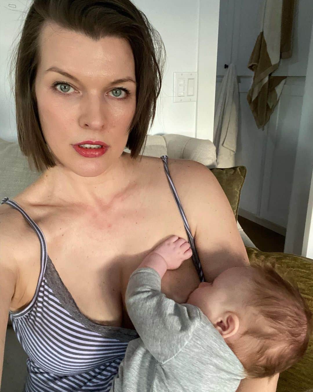 ミラ・ジョヴォヴィッチのインスタグラム：「So grateful for these quiet moments with my rainbow baby. Nursing her are some of my favorite times of the day. That sweet little cupcake looking up at me with her soulful eyes, her tiny hands, her incredible scent, that fluffy hair. I treasure this period of our lives so much. Such a short blip in my life, but one that will bring the sweetest memories when I’m looking back. #OsianElliot #perfection #quietmoments #mamasgirl #love *  Так благодарен за эти тихие моменты с моей радугой.  Уход за ней - одни из моих любимых дней.  Этот сладкий маленький кекс смотрит на меня своими проникновенными глазами, крошечными руками, своим невероятным ароматом, этими пушистыми волосами.  Я очень дорожу этим периодом нашей жизни.  Такой короткий всплеск в моей жизни, но он принесет самые сладкие воспоминания, когда я оглядываюсь назад.」