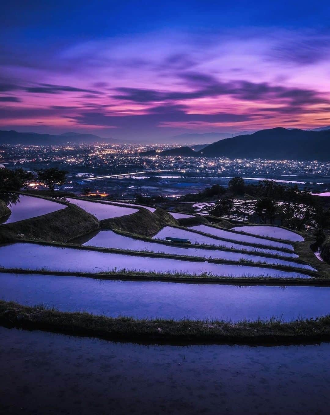 ?長野県 観光 公式インスタグラム さんのインスタグラム写真 - (?長野県 観光 公式インスタグラム Instagram)「//﻿ Photo by @ctrl_plus_v﻿ ﻿ The Terraced Rice Fields of Obasute﻿ (Chikuma City)﻿ ﻿ One of Japan’s top 100 terraced rice fields, they are flooded in spring before rice-planting and reflect the colors of the sky above.﻿ ﻿ Watching the changing colors of the still pools as the sun sets beneath the mountains is a breath-taking experience.﻿ ﻿ ==========﻿ ﻿ 名月の里さらしな﻿ 「姨捨の棚田」﻿ ＠千曲市﻿ ﻿ 「日本の棚田百選」のひとつ﻿ 田植えを控えて水を張られた﻿ 「姨捨の棚田」には﻿ 広く澄んだ空が映し出されます🌄﻿ ﻿ 静かに暮れていく空の色と街の灯﻿ 心休まる美しい風景です🍃﻿ ﻿ ーーーーーーーー ﻿ ﻿ Location /Chikuma City, Nagano, Japan ﻿ ﻿ #おうちでながの﻿ #おうちで過ごそう﻿ #長野のいいところ﻿ #姨捨の棚田﻿ #千曲市」5月5日 17時00分 - nagano_japan