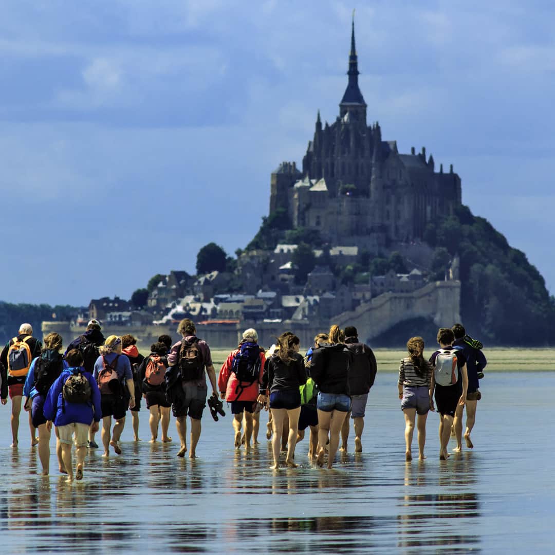 National Geographic Travelさんのインスタグラム写真 - (National Geographic TravelInstagram)「Photos by @babaktafreshi  While on most trips I’m imaging under stars and sleeping in daytime, on this summer day of Normandy I was off, attending my friends 10th anniversary celebration. The entire family and international guests took a day to cross the Saint-Michel Bay, walking on the ocean floor in low tide, towards the World Heritage monastery. This amazing several-mile walk is popular but has to be guided. The ground is swampy, includes fast streams even in low tide, and if you miscalculate the time the tidal flood rivers will come. This bay has the strongest tides in continental Europe where the sea goes out as far as 10 miles from the coast, becomes completely out of sight in a matter of few hours, and water returns in massive flood rivers. The exposed ocean floor in this view would be 40ft (12m) under water a few hours later, when Mont-Saint-Michel, one of Europe’s most unforgettable sights, becomes an island.  #normandie #brittany #france ##montsaintmichel @natgeo @natgeocreative」6月20日 8時40分 - natgeotravel