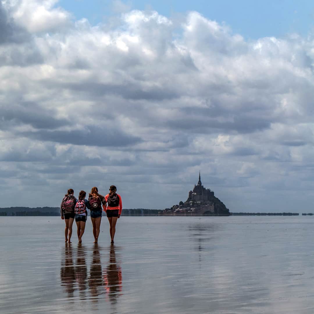 National Geographic Travelさんのインスタグラム写真 - (National Geographic TravelInstagram)「Photos by @babaktafreshi  While on most trips I’m imaging under stars and sleeping in daytime, on this summer day of Normandy I was off, attending my friends 10th anniversary celebration. The entire family and international guests took a day to cross the Saint-Michel Bay, walking on the ocean floor in low tide, towards the World Heritage monastery. This amazing several-mile walk is popular but has to be guided. The ground is swampy, includes fast streams even in low tide, and if you miscalculate the time the tidal flood rivers will come. This bay has the strongest tides in continental Europe where the sea goes out as far as 10 miles from the coast, becomes completely out of sight in a matter of few hours, and water returns in massive flood rivers. The exposed ocean floor in this view would be 40ft (12m) under water a few hours later, when Mont-Saint-Michel, one of Europe’s most unforgettable sights, becomes an island.  #normandie #brittany #france ##montsaintmichel @natgeo @natgeocreative」6月20日 8時40分 - natgeotravel