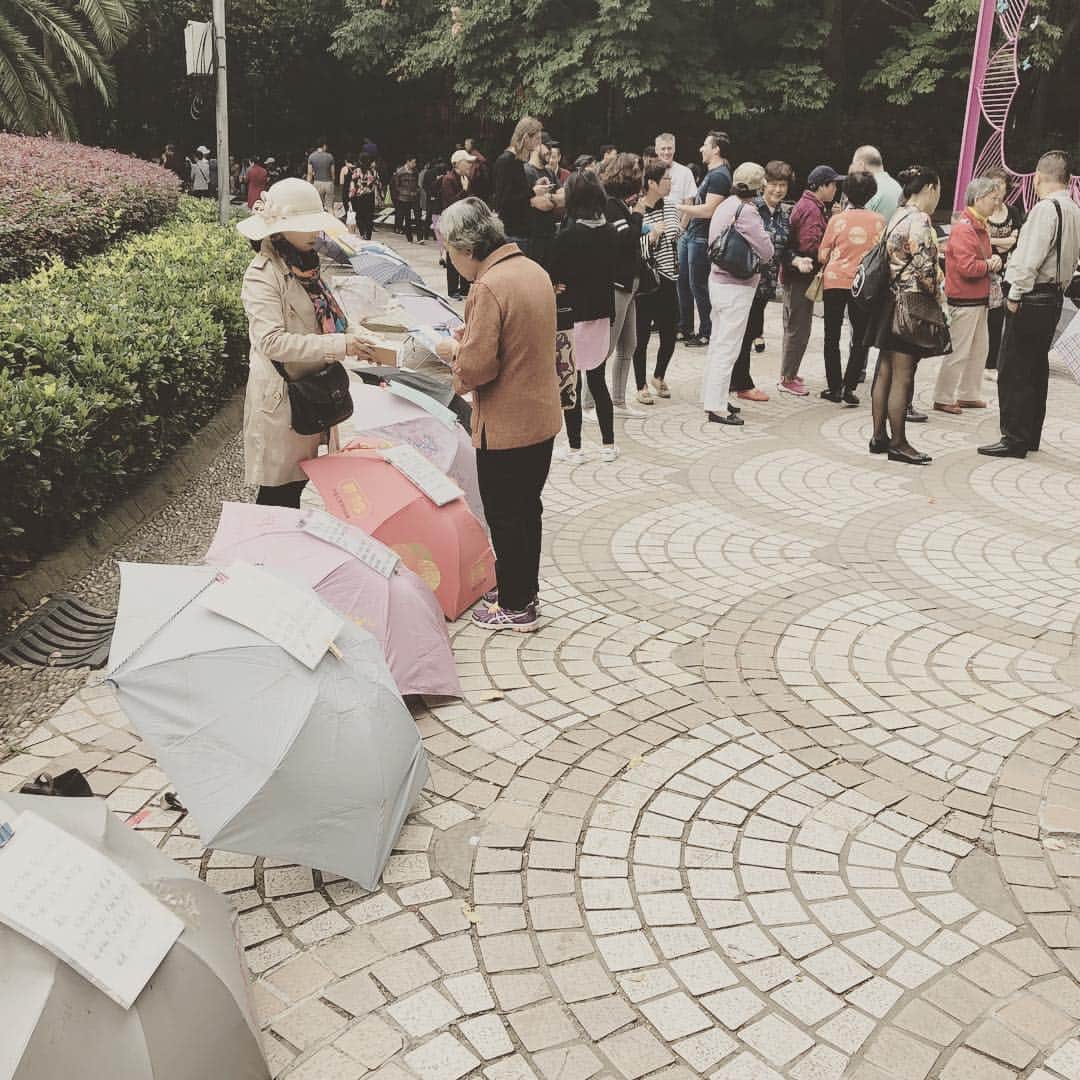 紀里谷和明のインスタグラム：「朝ごはん食べて上海の公園散歩してたら大量の傘。なんだこれと思って傘に貼り付けてある紙を読み続けてくと、どうやら結婚相手のマッチングをやっているらしい。そういえばこれどこかで聞いた事あるね。」