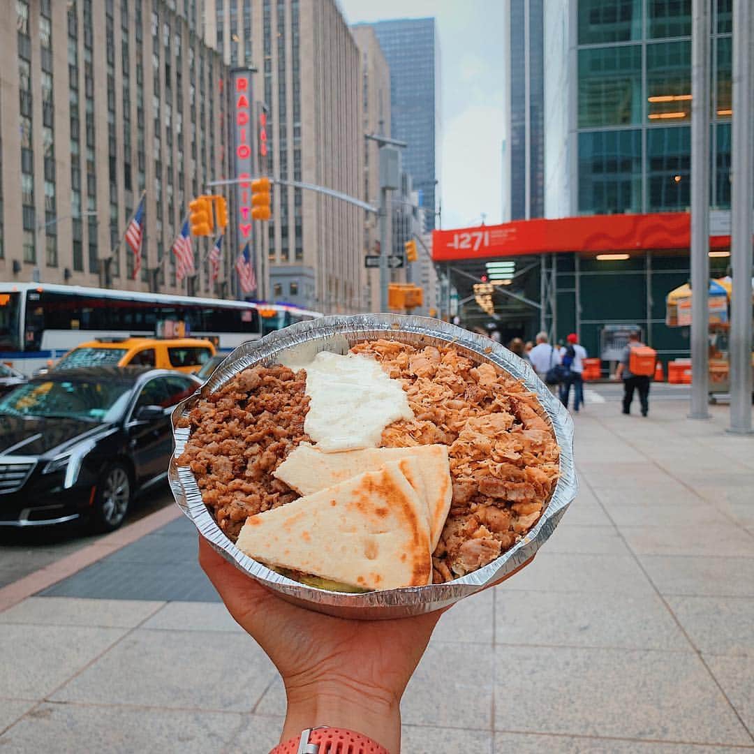 Girleatworldのインスタグラム：「🙌🏻 That famous Chicken & Gyro rice platter from Halal Guys @thehalalguys at West 53rd & 6th Avenue in New York City.  When I first visited NYC ten years ago, I was staying at a the Hilton right across this corner. Every night as I was coming back to the hotel, there was always a long line at this cart even when it was late into the night.  So one night I decided to see what's up and joined the queue. I got myself a combo chicken gyro platter - and... well, I loved it so much that I had to bring one back home, six hours flight be damned (at that time I was living in LA). I don't know what they put inside that signature white sauce but i knew I had to have more.  It wasn't until I got back home that I looked them up - you have to remember that this was before the days of smart phones, so to connect to internet you have to be on a laptop or computer. That’s when I found out they are THE Halal Guys.  When I came back to NYC a few weeks ago, of course I had to give them a visit. Happy to report they were every bit as good as I remembered. And that super spicy red sauce STILL got me good. 🔥  Nowadays there are plenty of halal carts around NYC, but @thehalalguys were the OG.  #halalguys #newyorkcity #nyc #newyork #gyro #chicken #rice #girleatworld #shotoniphone #iphonexsmax」