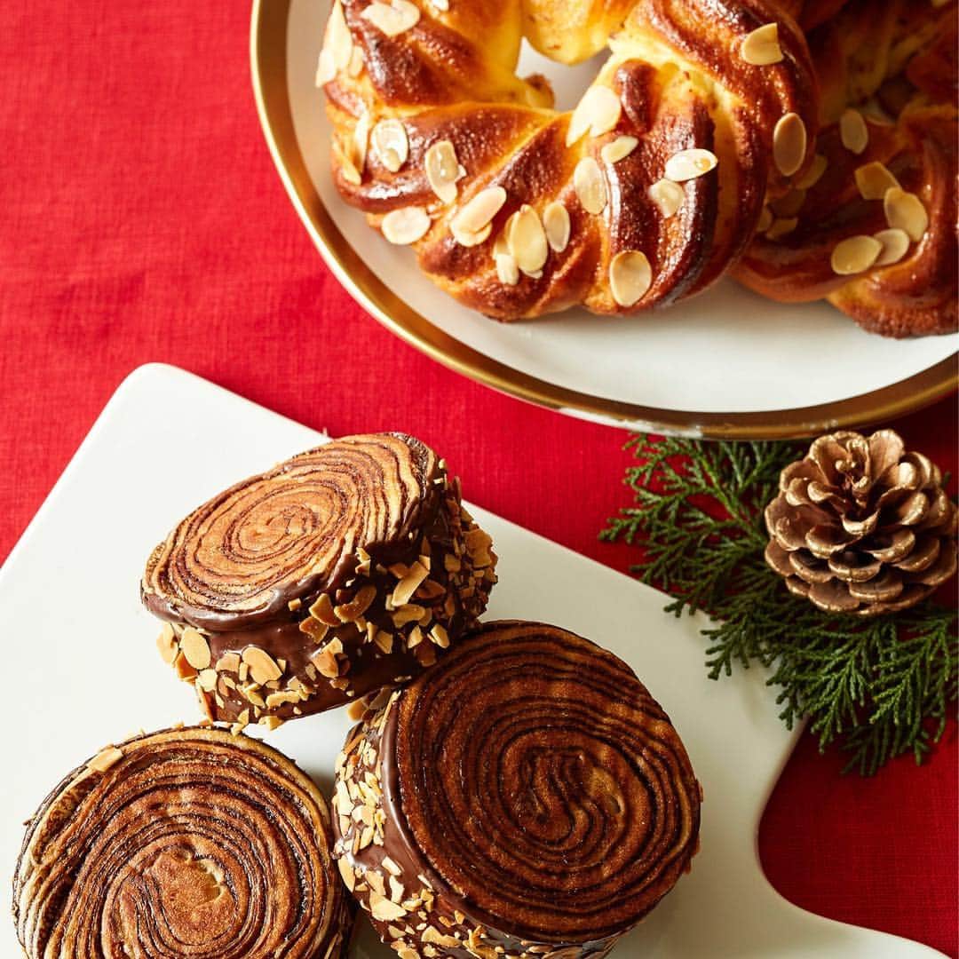 Afternoon Teaさんのインスタグラム写真 - (Afternoon TeaInstagram)「. 【クリスマス限定のパンご紹介】 ベイカリーとティールームのパン取り扱い店舗では、クリスマス限定のパンが順次登場しています★ . 「アップルカラメル」（画像1枚目） アップルとキャラメルクリームをスイート生地で巻き込み、タタン風に焼き上げました。カラメルの香ばしい苦みとリンゴの酸味がアクセント。 . 「リンゴのシュトーレン」（画像2枚目） 洋酒に漬け込んだドライアップル、オレンジ、レーズンをたっぷりと混ぜ込んで、しっとりと焼き上げたリンゴのシュトーレン。薄くスライスして、少しずつお召し上がりください。 イギリス在住の人気イラストレーター、ニナ・チャクラバーティさんによるリンゴのアートでラッピングしています。ご自宅はもちろん、手土産にもおすすめです。 ※冷やしてもおいしくお召し上がりいただけます。 . 「アップルティーブレッドリース」（画像3枚目・左） 定番人気の「アップルティーブレッド」（画像3枚目・奥）に、11/29～12/25の期間限定でリース型が登場！アールグレイの茶葉を入れたスイート生地でリンゴとアーモンドクリームを巻き込み、ボリュームたっぷりに焼き上げました。 . 「ビターチョコ＆ラムレーズンロール」（画像4枚目・右） 濃厚な味わいの冬限定パン 。 ビターチョコとブラックココアの生地に、ラムレーズンを合わせて焼き上げました。 . 「クッキークリーム ビターチョコ＆フランボワーズ」（画像4枚目・左） フランボワーズジャムとビターチョコをスイート生地に合わせ、深紅の生地で包み焼き上げました。 ※11/29発売 . 「アーモンドリース」（画像5枚目・奥） スイート生地にアーモンドクリームを巻き込み、アーモンドスライスを散らしリース型に焼き上げました。 . 「ブッシュドノエルショコラ」（画像5枚目・手前） ブッシュドノエルをイメージした冬限定のパン。ビターチョコとアーモンドをトッピングしました。 ※11/29発売 . パン取り扱い店舗などの詳細は、ストーリーズのリンクからご覧ください。 . ※発売日の記載のない商品は現在販売中です。 ※店舗により取扱商品及び販売期間が異なります。 ※食材の都合などで日時によっては商品をご用意できない場合がございますので、あらかじめご了承ください。 ※天候不良などにより、予告なく食材が変更になる場合がございます。 . #アフタヌーンティーベイカリー #アフタヌーンティーティールーム #AfternoonTeaBAKERY #AfternoonTeaTEAROOM #クリスマス #パン #ベイカリー #期間限定 #林檎 #りんご #リンゴ #シュトーレン #アップル #クリスマス限定  #christmas #apple #bakery #ニナチャクラバーティ さん」11月15日 10時56分 - afternoontea_official