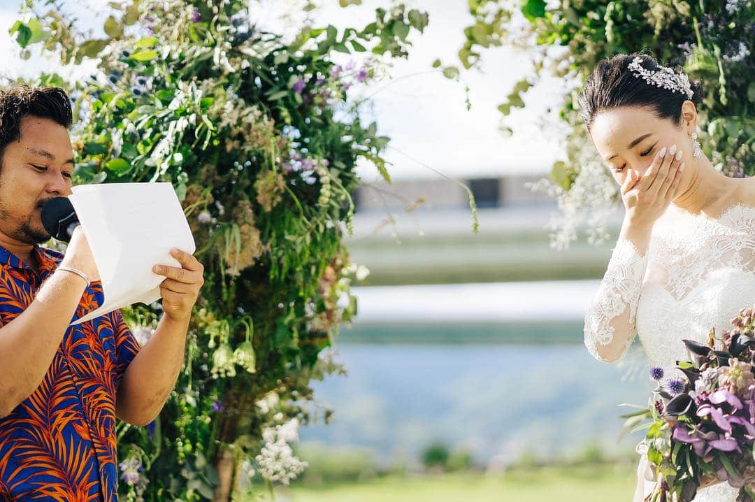 【CRAZYWEDDING_大阪支社】のインスタグラム：「・ 「挙式に、牧師さんがいなくてもいい。」 ・ 神様からの教えや 賛美歌の神秘さの素敵さもある。 ・ 何年たっても意味があるのは、 どんな誓いだろう？ ・ 決められた文章を読み上げるのではなく、 お互いへの愛をお手紙にしたため、 大切な人たちの前で 伝え合う。 ・ ふたりのストーリーが垣間見えた瞬間 溢れてくる感情があるかもしれない。 ・ そんな誓いも素敵。 ・ ・ concept : 杯の唄 producer : @cw_tomoya_takahashi_  art direction : @iida.satoshi  flower : @giraffe_flower photo : @kuppography / @moments.ink movie : @maimai_tomatoredmotion hair and makeup : @ikki919 MC : @mc_nishigaki . . #結婚式に自由を #crazywedding #クレイジーウェディング #ブライダル #結婚式 #オリジナルウェディング #コンセプトウエディング #結婚式準備 #卒花嫁 #プレ花嫁 #花嫁diy #ウェディングフォト #全国のプレ花嫁さんと繋がりたい #日本中のプレ花嫁さんと繋がりたい #結婚式レポ #前撮り #weddingtbt #marry花嫁 #weddingphoto #art #instagood #野外ウェディング #高砂 #outdoorwedding # #芦屋 #新郎衣装 #花嫁ドレス #ブーケ」