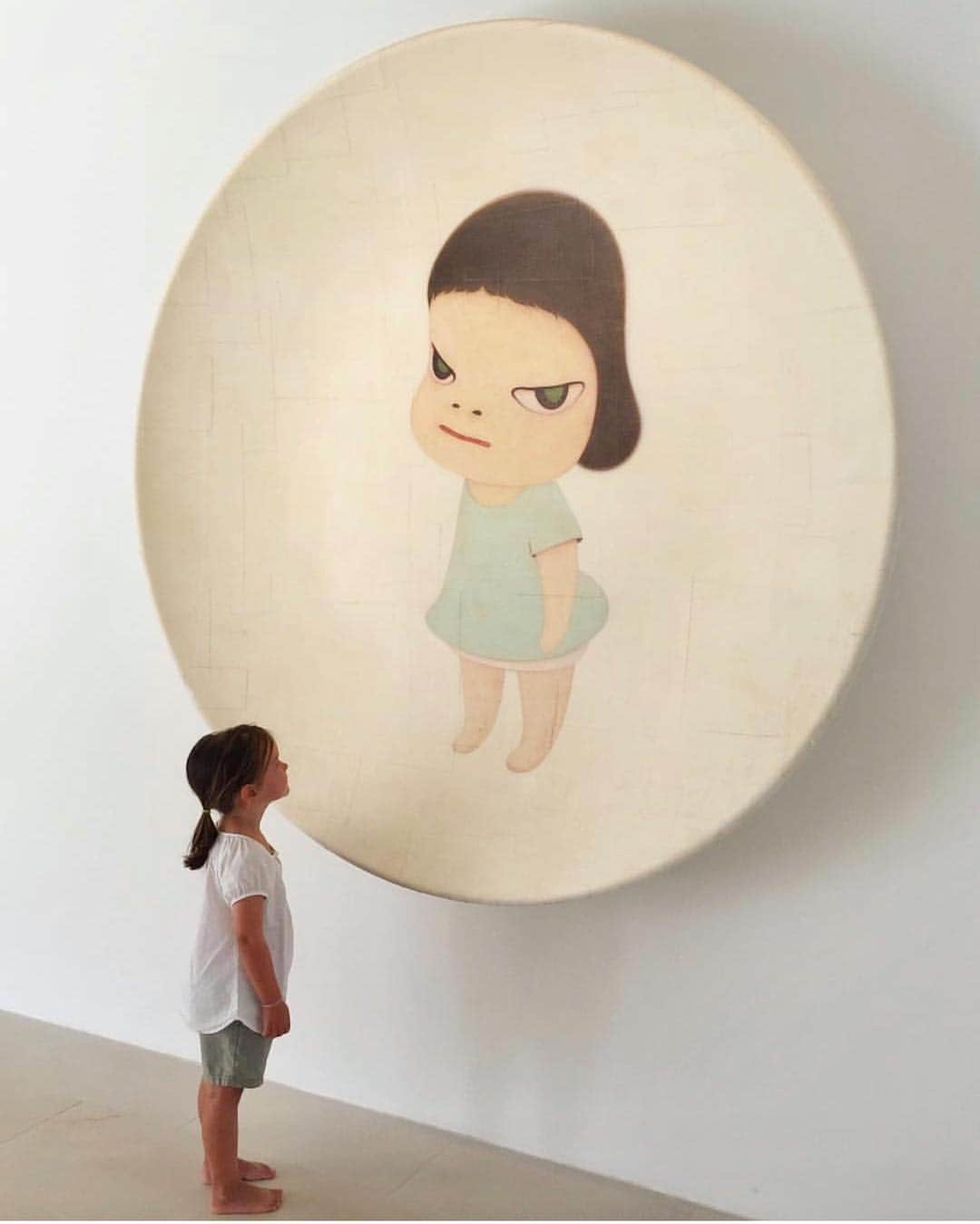 奈良美智のインスタグラム：「“Standing for Action (2001)” looks nice with a little girl.  original posted by @stickerbookmajolo Merci, je suies content.」
