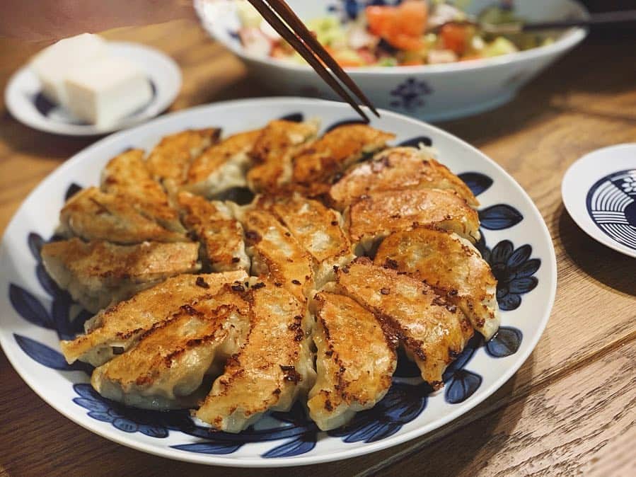 猪鼻ちひろのインスタグラム：「餃子の陳さん登場🥟👲🏻 50個包んで焼いたぞー！ 教えてもらった大葉と海老入りの餃子も めちゃくちゃ美味しかった😍🙏🏻💯 餃子の他にはタコとセロリのサラダと麻婆春雨を作りましたとさ。 ①第一回目の餃子 後ろに写る冷奴 ②第2回はフライパンと油を変えて実験 ③#ストウブ炊飯 水は3合で630mlに増やしてみました たのしい日曜日でした♡ #誰かと包む楽しさ #最高 #待てないひとがいるため箸が全部入ってる🥢笑  #餃子 #もやし餃子 #海老と大葉の餃子  #ちひろのごはん #ちひろkitchen」