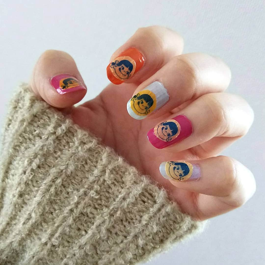 sweet_strawberryさんのインスタグラム写真 - (sweet_strawberryInstagram)「【春ネイルしたよ💅】→【貼るネイル】 ペーパーナプキンを切って貼ってコーティングする【#デコパージュ 】みたいに、 🍬#ミルキー の#ペコちゃん 😋の包み紙を切って貼ってトップコートしたよ💅 . 🛒また、(怖いもの見たさで？) アノおじさんがいるスーパーに行って、おじさんにレジをしてもらったら、 …やっぱり、お釣りを暗算された。🗿(おじさんより早く暗算して言ってやろうか？と思ったけど🙊) そして、何かと世話を焼いてもらったと言うか、 ５箱ティッシュBOXを買ったら、 ｢持てますか？ 持ちやすいようにティッシュをレジ袋(無料)に入れましょうか？｣って言われた…。🗿 私｢いえ、大丈夫です。｣って答えたけど、 ５箱ティッシュBOXやトイレットペーパーを袋に入れて持とうなんて思ったことないし、ドラッグストアでレジで袋詰めしてもらって両手いっぱいに買い物した時に、店員さんに、持てますか？って声をかけてもらう事はあるけど、ティッシュを袋に！なんて対応してもらった事ないから、ビビッた🤣 凄いねおじさん！☺️ 🍬#包み紙#お菓子の包み紙#2月28日#不二家の日 💅#春ネイル#セルフネイル#斬新#キャラクターネイル#ネイルチップ#ネイル検定#キャラクター#爪#手#手元くら部 【#貧乏くさい 🤣】」2月21日 18時07分 - sweet_strawberry