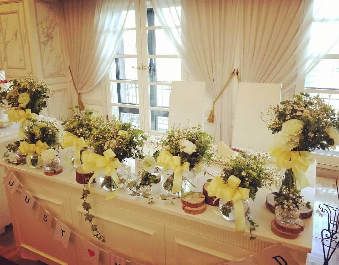 ホテルモントレ大阪 ブライダルサロンさんのインスタグラム写真 - (ホテルモントレ大阪 ブライダルサロンInstagram)「先日ご用意させていただいた高砂装花です。ガラスに花束風に仕上げた装花を入れています。グリーン多めで小花と黄色のリボンがうまくマッチしています！#黄色#グリーン#白#かすみ草#マトリカリア#スターチス#ナチュラル#ガラス#リボン#丸太#モントレ大阪#梅田#結婚式#プレ花嫁#大阪#ウェディング#アンティーク#ホテル#モントレ#wedding」4月8日 12時27分 - monterey_osaka