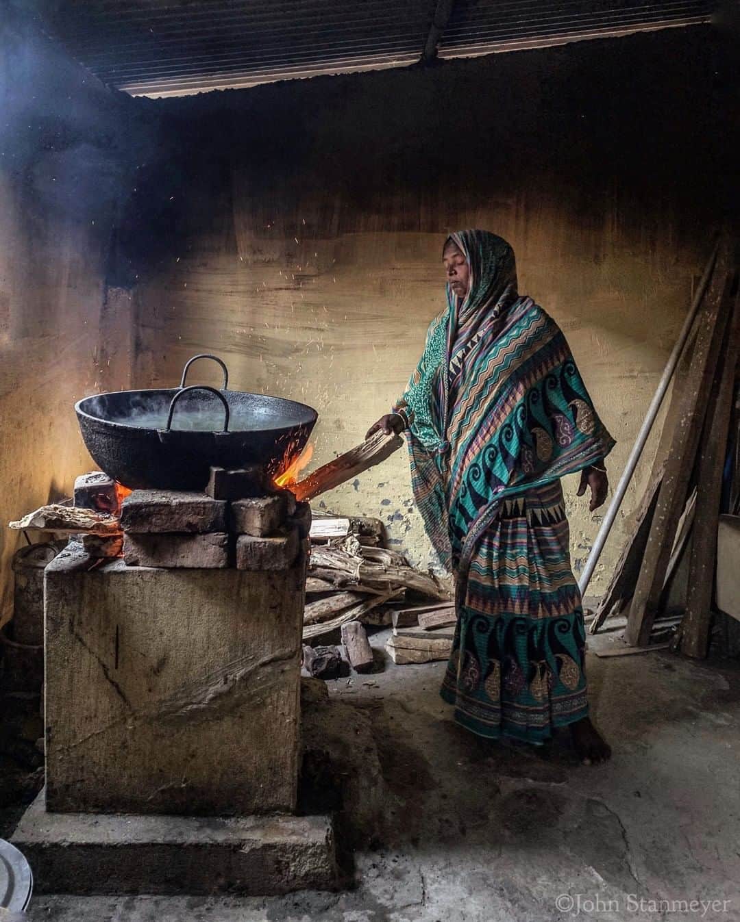 のインスタグラム：「Photo by @johnstanmeyer | We did not have the time to wait for the khichdi that Shohitun Bibi was preparing in the kitchen. We needed to leave; where to, I can’t remember. Only recalling that while in India for @natgeo @outofedenwalk assignment we continued eastward, always sidetracked by so much of all the much that is India, after leaving the Dhubri Girls Academy, in Assam state, that morning. @natgeoimagecollection @outofedenwalk #india #assam #Dhubri #kitchen #fire #smoke #woman #cooking #khichdi」