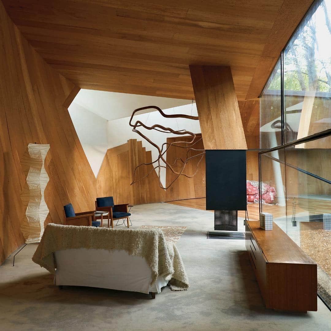 ニューヨーク・タイムズさんのインスタグラム写真 - (ニューヨーク・タイムズInstagram)「This living room in Chile is clad in Bolivian cedar and pierced by a jagged skylight. “Drawing,” a sculpture by Marcella Correa, is suspended near 1960s chairs and a slipcovered sofa facing the fireplace. Welcome to the “House for the Poem of the Right Angle” by the Chilean architect Smiljan Radic. Smiljan named the house — located on a plot of land in #Vilches, a pastoral village at the edge of the #Andes — after a series of lithographs and corresponding poems composed by Le Corbusier between 1947 and 1953. “I am a builder of houses and palaces,” #LeCorbusier wrote. “To make architecture is to make a creature.” At only 1,991 square feet, the house is intimate, peculiar and inscrutable, a pure creation of Smiljan’s imagination. Visit the link in our profile to see more from @tmagazine of #Chile’s unique and spectacular takes on #modernist architecture. @jasonschmidtstudio shot this photo.」4月5日 0時01分 - nytimes