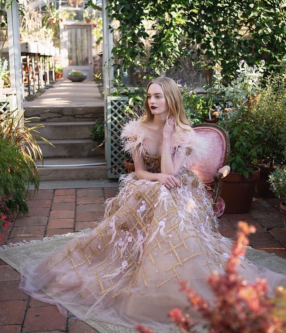 のインスタグラム：「Look 28: Pale off shoulder blush ballgown with flutter sleeves, 3D gold thread-work flowers and antique gold lochrose grid, floral and feather embroidery on set at the Pre-Fall 2019 Marchesa shoot. Photo by @joannatotolici. #marchesa #pf19marchesa」