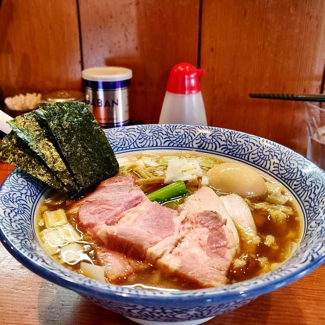 のインスタグラム：「＿＿＿＿＿＿＿＿＿＿＿＿＿＿＿＿＿ 🍜：特製手揉み中華蕎麦(醤油) 🏠：麺処 ほん田(東十条) ￣￣￣￣￣￣￣￣￣￣￣￣￣￣￣￣￣ 【自らの手でおいしいものを提供する人】 昼飯難民になりかけた大宮からの帰り道で救ってくれたのはほん田。黒松と埼玉屋の行列の先にまた行列。今日は久しぶりに中華蕎麦をいただこう… . ちゃっくどぉ〜ん！！ . 背脂の加わったこのスープがコクもあって、醤油の香りもあってうめぇ。人を選ばないおいしさってこういうことだよな。そこに手揉みした麺がうまいのなんの。 レアチャーシューに凄まじく肉を食べている感を出し、吊るし焼きチャーシューの燻香豊かな味もすごく好き。 ちゃんと店に立っておいしいものを作るってのが好きなんだなぁとしみじみいただいた。」