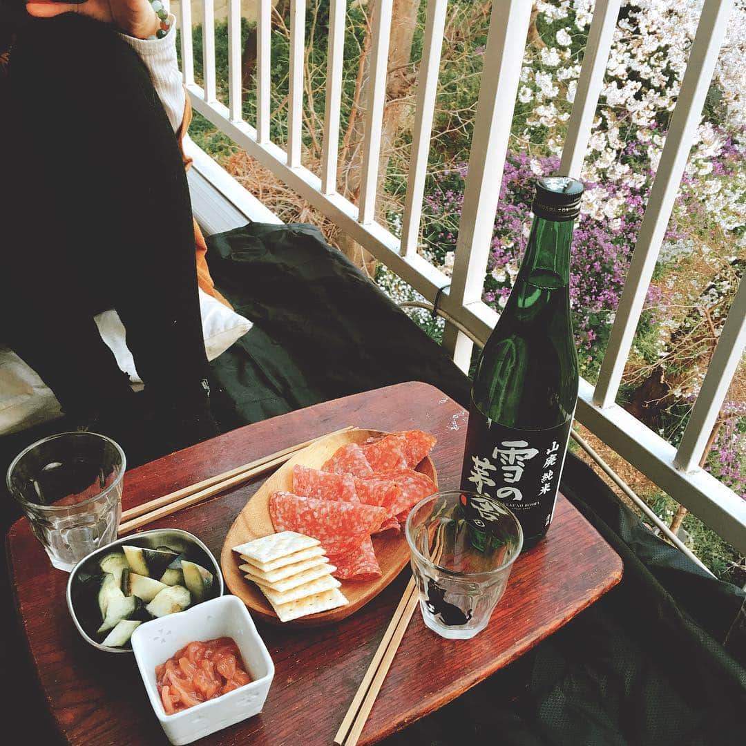 のインスタグラム：「ベランダ花見。この家に内見に来た時、ちょうど桜が満開でそれ見てこの部屋に決めたんだよな。あれから3年か。 そこからの炊き込みごはん（なに食べリクエスト）、そしてキンプリ。 ＊＊＊ 炊き込みごはんはかにかまと油揚げときのこ。あとは差し入れでもらった鯖缶に、トマトとほうれん草でチーズ焼き、シーフードミックスとえのきとしらすでアヒージョ、キャロットラペ。ベランダでは、ソフトサラミと水茄子とイカ明太です。 ＊ あとで炊き込みごはん別投稿しよっとw #花見 #おうちごはん #炊き込みごはん #キャロットラペ #アヒージョ #おうちごはん金巻」