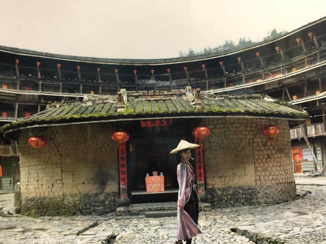 エリイ さんのインスタグラム写真 - (エリイ Instagram)「遂に行きたかったシリ〜ズ念願の土楼へ‼︎‼︎‼︎‼︎‼︎ キャッチコピーは 【東へ西へ傾いて700年】 土楼とは客家が建てその一族が住む巨大集合住宅！ 入り口一つしかなく外敵攻めにくい。 中国には2万個ある。 朽ち果てたり栄えたり個性あり。 最初の写真は土楼に入ると、そこに住んでるカメラマンのおっちゃんがほぼ無理矢理写真を撮り光速より早くラミネ〜トして持ってきて10元で売ってきます。ポーズの指導あり。 私はこのおっちゃんを上の階まで召喚してフォトセッションしました。このおっちゃん、土楼のいい角度でしか切らなくてこだわってて最高！10枚くらい買った。 最後のは違う土楼でこの世に私一人しかいないみたいだけど、写真係のしつこいおばちゃんが全ての観光客をどかし、二階にくくってあるカメラを見ろと言い、ポーズの強制を行ったのちに、横のお土産屋に座ってた男の子がボタンを押して遠隔で撮影。これも10元で光より速くラミネ〜トして持ってくるのであーる。全員ありがとう。」4月7日 21時27分 - elliechimpom