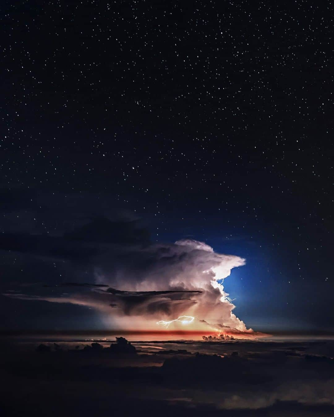 National Geographic Travelさんのインスタグラム写真 - (National Geographic TravelInstagram)「Photo by @BabakTafreshi | On this summer night I was on the edge of Haleakala volcanic crater, about 10,000 ft high on the Hawaiian island of Maui. Most visitors come to the summit for sunset or sunrise views. But to me, as a night photographer for 2 decades, the real show is dusk to dawn! Haleakala is a superb stargazing location due to altitude and thin air, being away from light pollution, and often above the clouds. It was 2 in the morning. The crystal clear sky was filled with stars but on the distance, over the Pacific Ocean, thunderstorm was flashing in a supercell cloud every minute. I was imaging close up views with a telephoto lens but let enough of the star-filled sky in constellation Ophiuchus to embrace the subject. If you walk into any of the National Geographic Fine Art galleries across the country this is one of the exhibited images. Explore more of The World at Night photography @babaktafreshi.」4月8日 1時03分 - natgeotravel