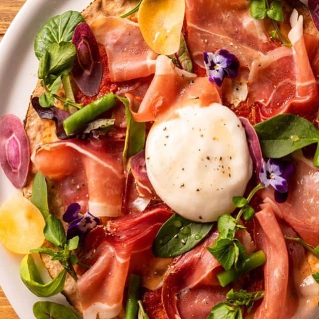 のインスタグラム：「本日3月15日(金)より、「800°DEGREES」×東京カレンダーのコラボピッツァ2種が1カ月限定登場！ 燻製生ハムがはみ出すほど豪勢に盛られた1枚は、野菜と生ハムの海の中からのぞくエディブルフラワーが華やかさをプラス。鴨、フォアグラ、トリュフなどの高級食材を贅沢にのせた1枚は、ジューシーで肉感のある本格派。 はみ出す生ハムか、豪華にフォアグラか、あなたはどっち？  #4月15日まで #800degrees #800degreespizza #カスタマイズ #ピザ #ピッツァ #有楽町 #東京国際フォーラム  #コラボピザ #コラボピッツァ #こぼれ燻製生ハムとフレッシュブラータのグルテンフリーピッツァ #鴨とフォアグラトリュフのピッツァ #燻製生ハム #フレッシュブラータ #グルテンフリー #鴨 #フォアグラ #トリュフ #東京カレンダー #東カレ #tokyocalendar #PR」