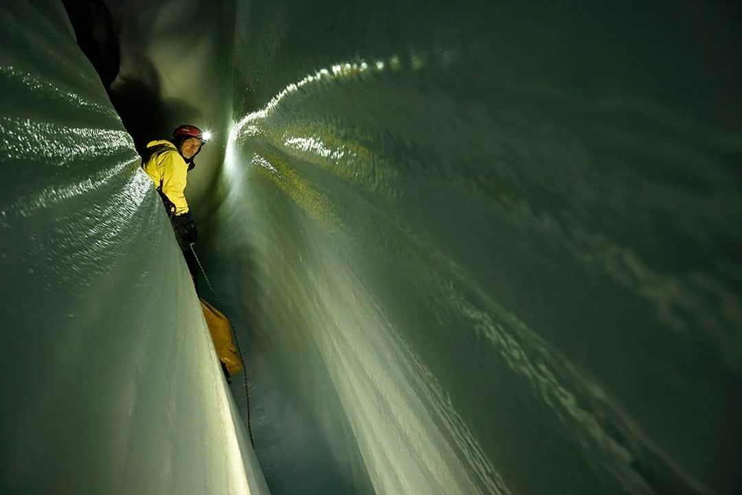 のインスタグラム：「Photo by Robbie Shone @shonephoto | An Italian explorer edges his way along a narrow passage carved out by meltwater, deep beneath the surface of the Gorner Glacier in Switzerland. What's around the next corner? Will it end soon, or will it keep going? Scientists study these icy tunnels to better understand how and at what rate glaciers move.」