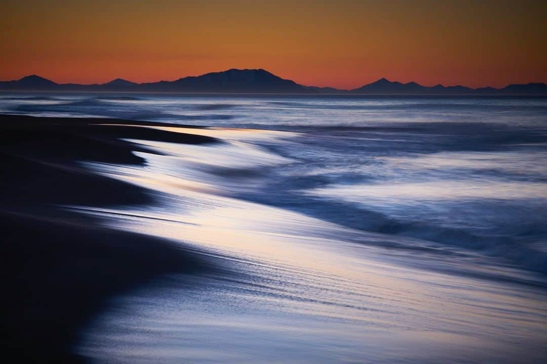 National Geographic Travelさんのインスタグラム写真 - (National Geographic TravelInstagram)「Photo by @simonnorfolkstudio I The black volcanic sand of Khalaktyrsky Beach in the Kamchatka peninsular, Russian Far East, with Cape Nalychevo on the horizon. The iron, vanadium and titanium-rich sand lies 20m (65ft) deep and the beach stretches for 30km (19miles). Towards the end of the Second World War Kamchatka and its beaches served as a launch site for the invasion of the Kuril Islands and after the war the Soviet military designated the area a military zone: it remained closed to Soviet citizens until 1989 and to foreigners until 1990. Follow @simonnorfolkstudio for updates, outtakes, unpublished and archive material. #beach #CapeNalychev #Khalaktyrsky #KhalaktyrskyBeach #Kamchatka #камчатка #landscape #simonnorfolk  #russia #igtravel #instagramrussia @simonnorfolkstudio」3月15日 10時04分 - natgeotravel