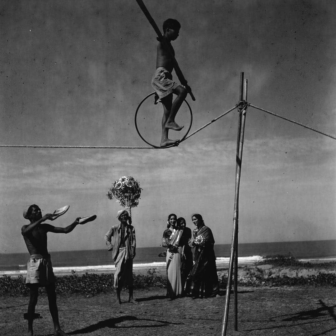 のインスタグラム：「Photo by Volkmar Wentzel | A young boy walks a tightrope while balancing a beam in Bombay, India. #ThrowBackThursday #BlackAndWhite #India」
