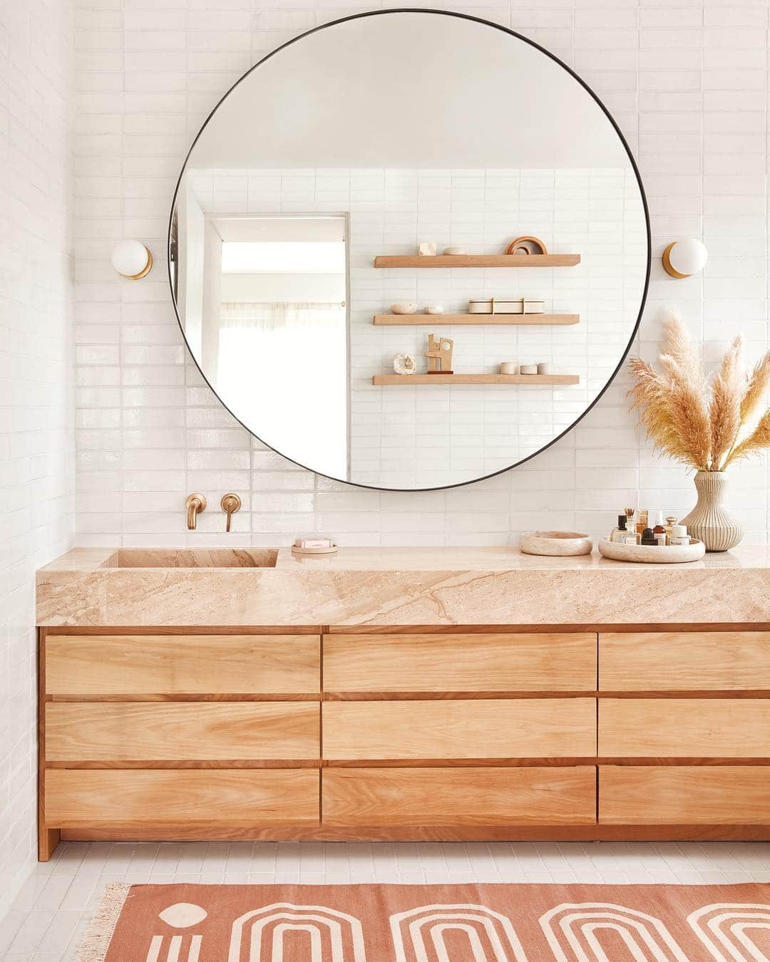 ギャランス・ドレさんのインスタグラム写真 - (ギャランス・ドレInstagram)「...Where I plan on spending my weekend! . This is a dream come true. A bathroom just for me, but we could totally have champagne in my bathtub. It’s the place where I bathe, shower & put on my make up, but also where I have solo naked dance parties, sing like if I was - depending on the mood Barbra Streisand, Kendrick Lamar or Chan Marshall. I do a lot of my home exercise in there, I read too. . I’ve always been like that with bathrooms. Maybe part of it is my Moroccan culture? They’re a super important part of the house to me... Even if no one really gets to see it. It’s like a bedroom - it’s a reflection of our interior world that not many get to see, yet that’s where the magic happens ☺️ . I’d been bathroom frustrated for so long! . When it was time to think about my first real bathroom @sarahshermansamuel and I went for it. . I wanted a lot of space for my beauty products. I didn’t want a double sink - a weird pet peeve of mine, don’t judge - and I dreamt of a vanity because I love to be able to sit down to do my make up & whatever grooming stuff a woman has to do. . I of course wanted tile (what’s more beautiful than tile?), and a place as bright as possible, even with a small window. So these light shiny tiles bring that extra glow! Then for stone we chose travertine. It reminded me of interiors of the 80s which I love. I also wanted warm tones - so of course natural untreated wood had to be there. . Then ask Sarah about this amazing round mirror because that’s totally her genius. Having someone to source pieces for you is one of the best parts of working with a designer! . Mmm what else? I’ll show you more about that room soon. And I have to say I feel incredibly lucky I have a space like that, made just for me. I really do. . For the full house story on @dominomag follow the link in my bio! . Interior designer : @sarahshermansamuel  Photos : @jasonfrankrothenberg  Editor : @kateberryberry  Styled by : @thelocationist_  Thank you @lilyksullivan and all the teams at @atelierdore and @dominomag !!! . Tile : @fireclaytile  Stone : @stoneland.usa  Mirror : @crofthousela  Sconces : @hudsonvalleylighting  Faucet : @deltafaucet  Rug : @blockshoptextiles」3月17日 0時29分 - garancedore