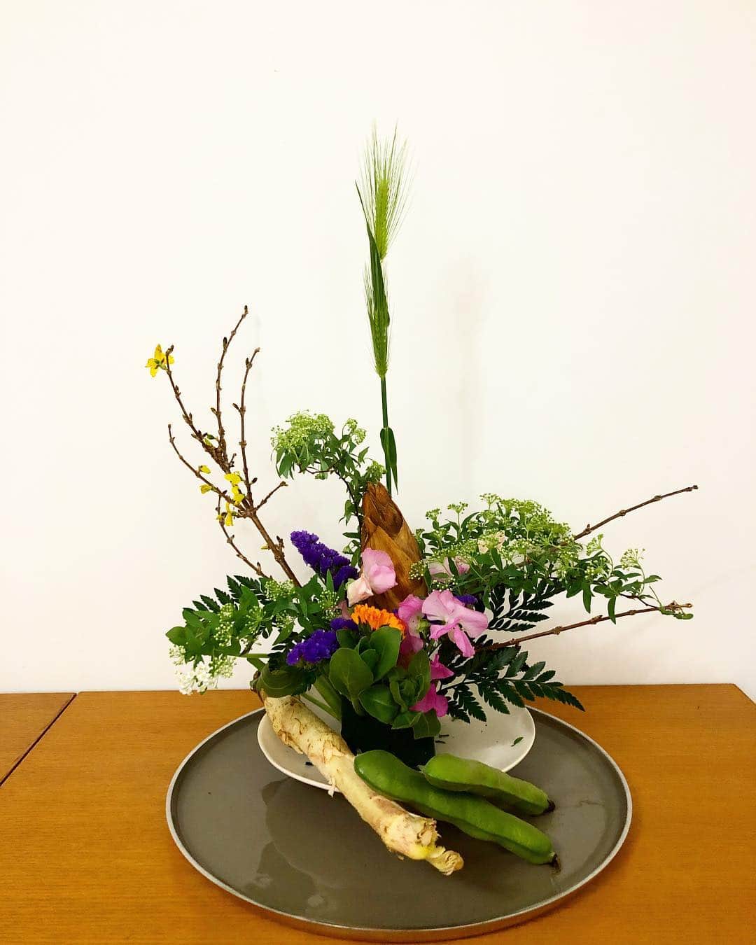 のインスタグラム：「#卯月の室礼 #花祭り のお稽古の後、盛り直して復習。 顔を出したばかりの竹の子=笋(シュン)は仏影蔬(ブツエイソ)とも言われお釈迦様に見立てます。 笋、独活、空豆、金盞花、麦、連翹、スイートピー、小手鞠、スターチス #室礼三千 しかしコレも1日で#れぇこともへじ によって破壊…😭」